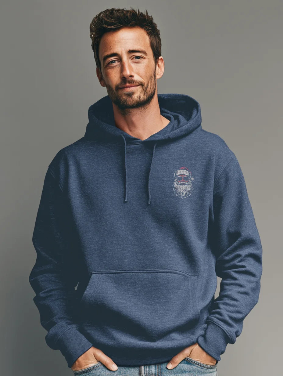 Heather navy men’s hoodie with small vintage Santa face and sunglasses chest print, modeled by a man standing in a studio with a gray background, hands in the front pocket.