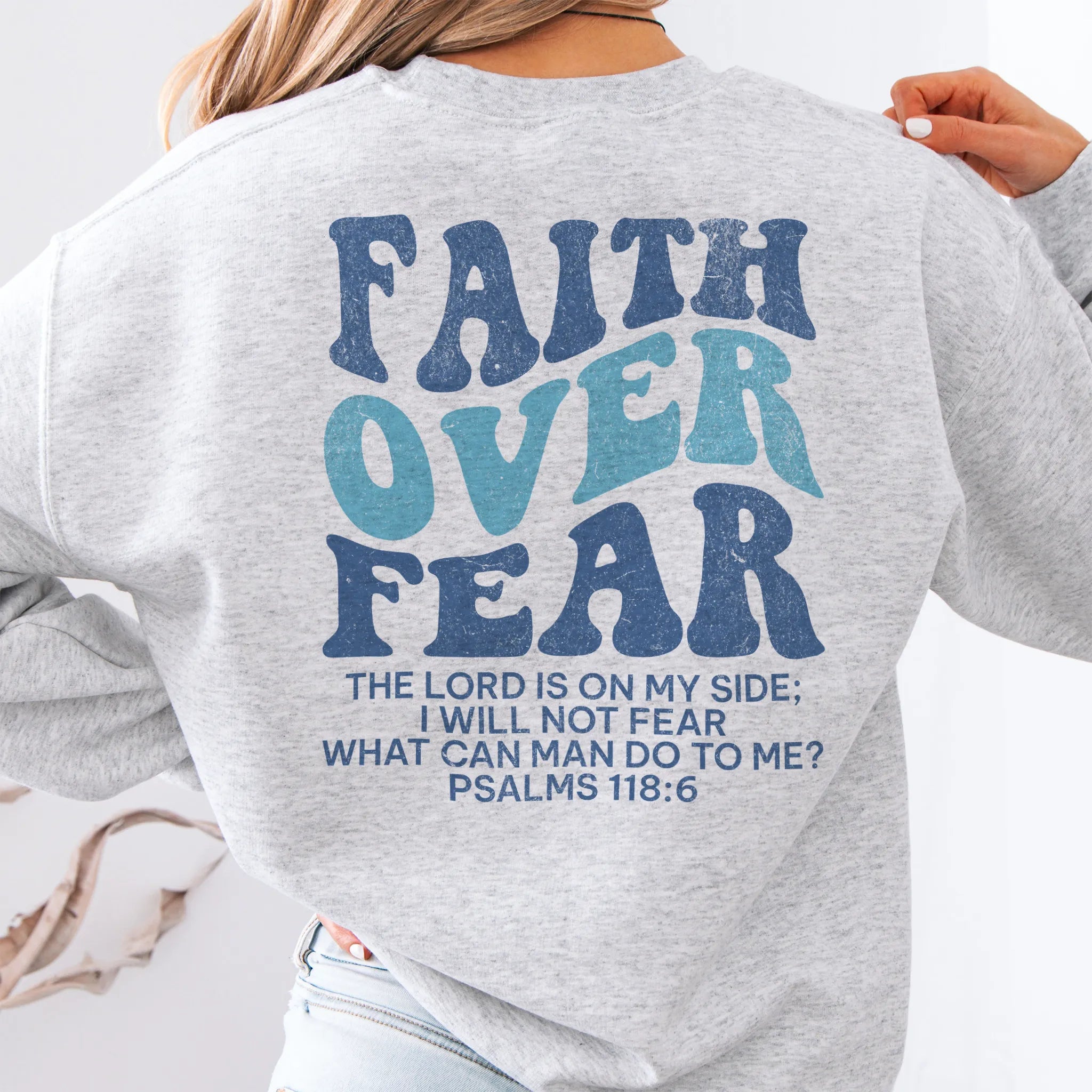Ash Oakley June sweatshirt, large back lettering reads Faith Over Fear with supporting scripture lines, studio back view