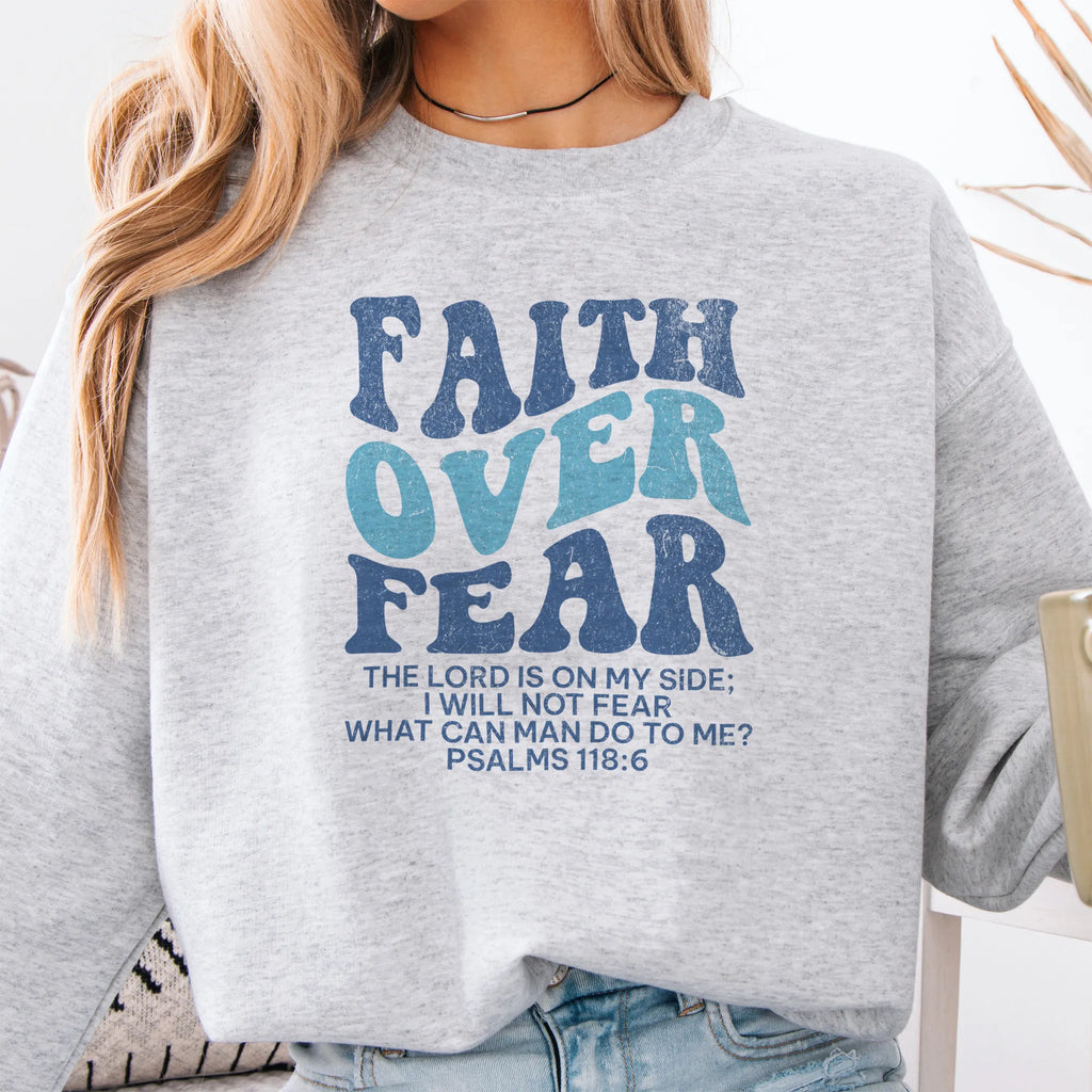 Ash Oakley June sweatshirt, large front lettering reads Faith Over Fear with supporting lines The Lord Is On My Side I Will Not Fear What Can Man Do To Me, studio front view