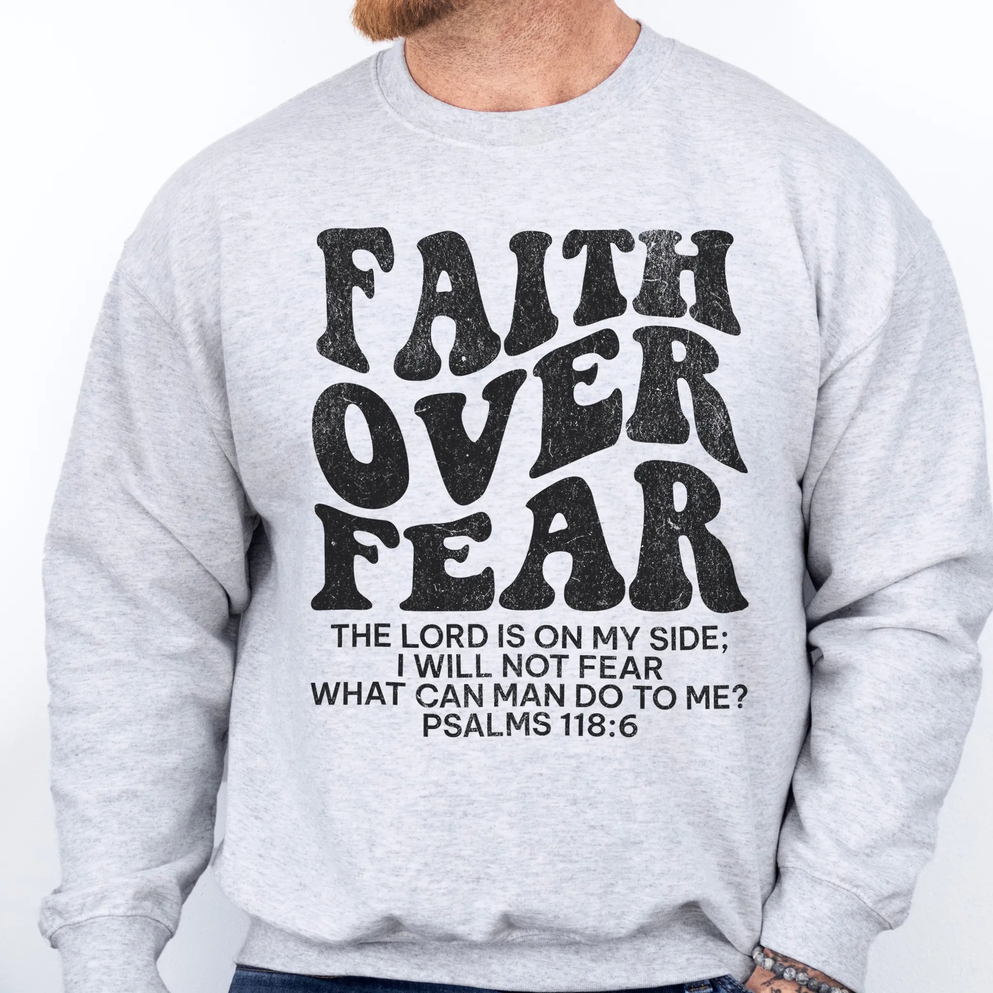Ash Oakley June sweatshirt, mens fit, left chest badge reads Faith Over Fear with cross, studio front view
