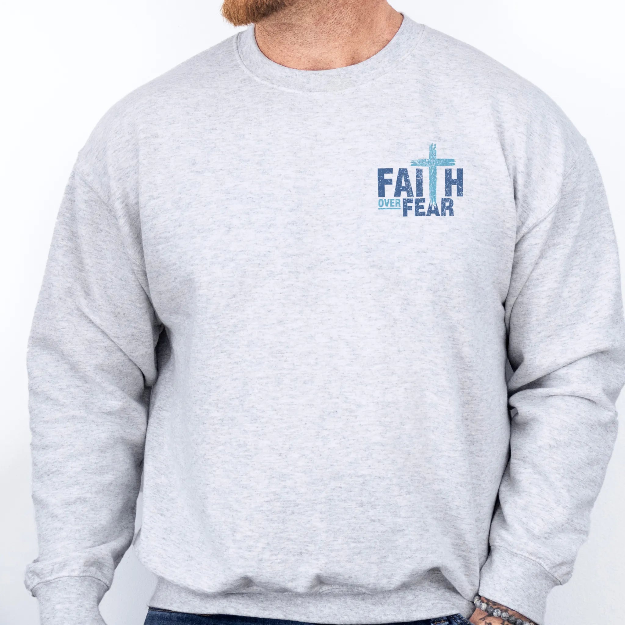 Ash Oakley June sweatshirt, mens fit, left chest badge reads Faith Over Fear with small cross, studio front view