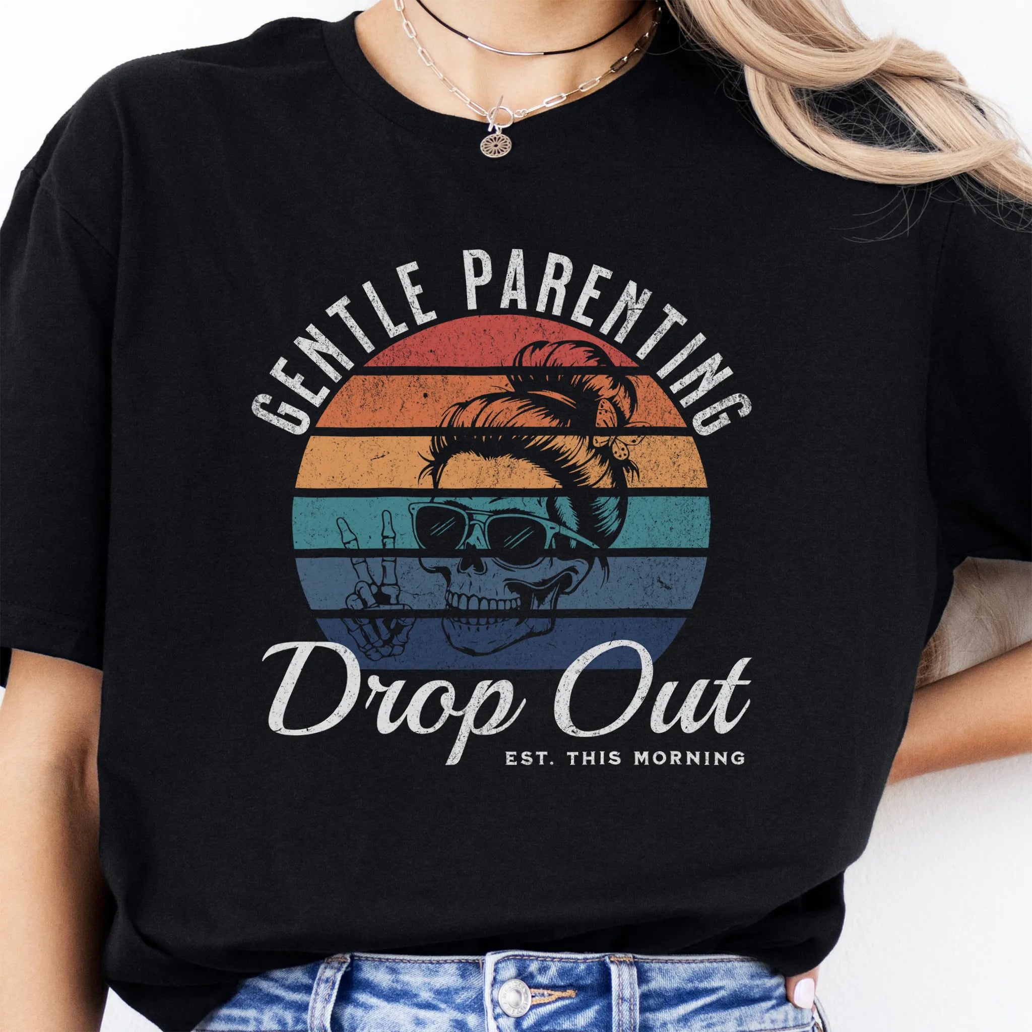 Black Oakley June T Shirt front view Gentle Parenting Drop Out large chest graphic skull with messy bun sunglasses peace sign round retro stripe badge text Est This Morning distressed print