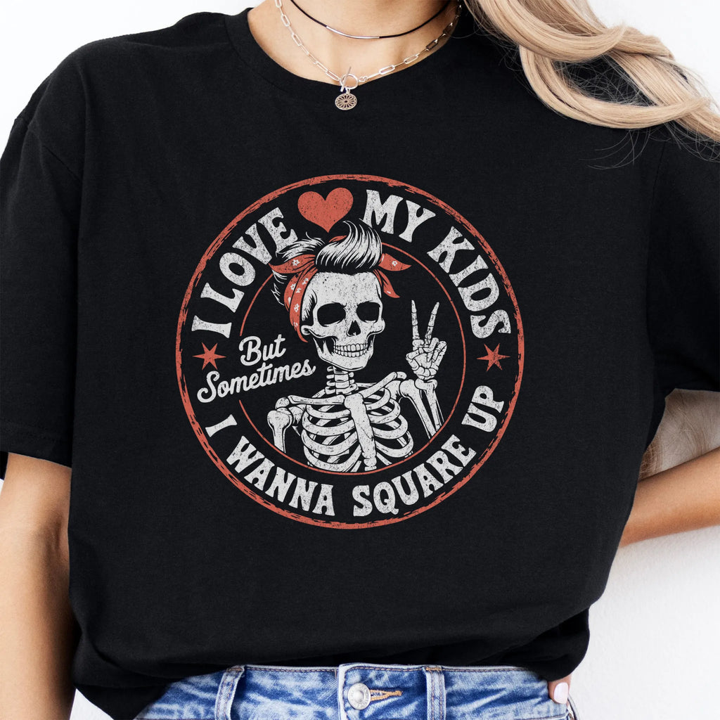 Black t-shirt – large front circle graphic with skeleton mom in bandana and peace sign, headline reads “I Love My Kids But Sometimes I Wanna Square Up”, studio front view