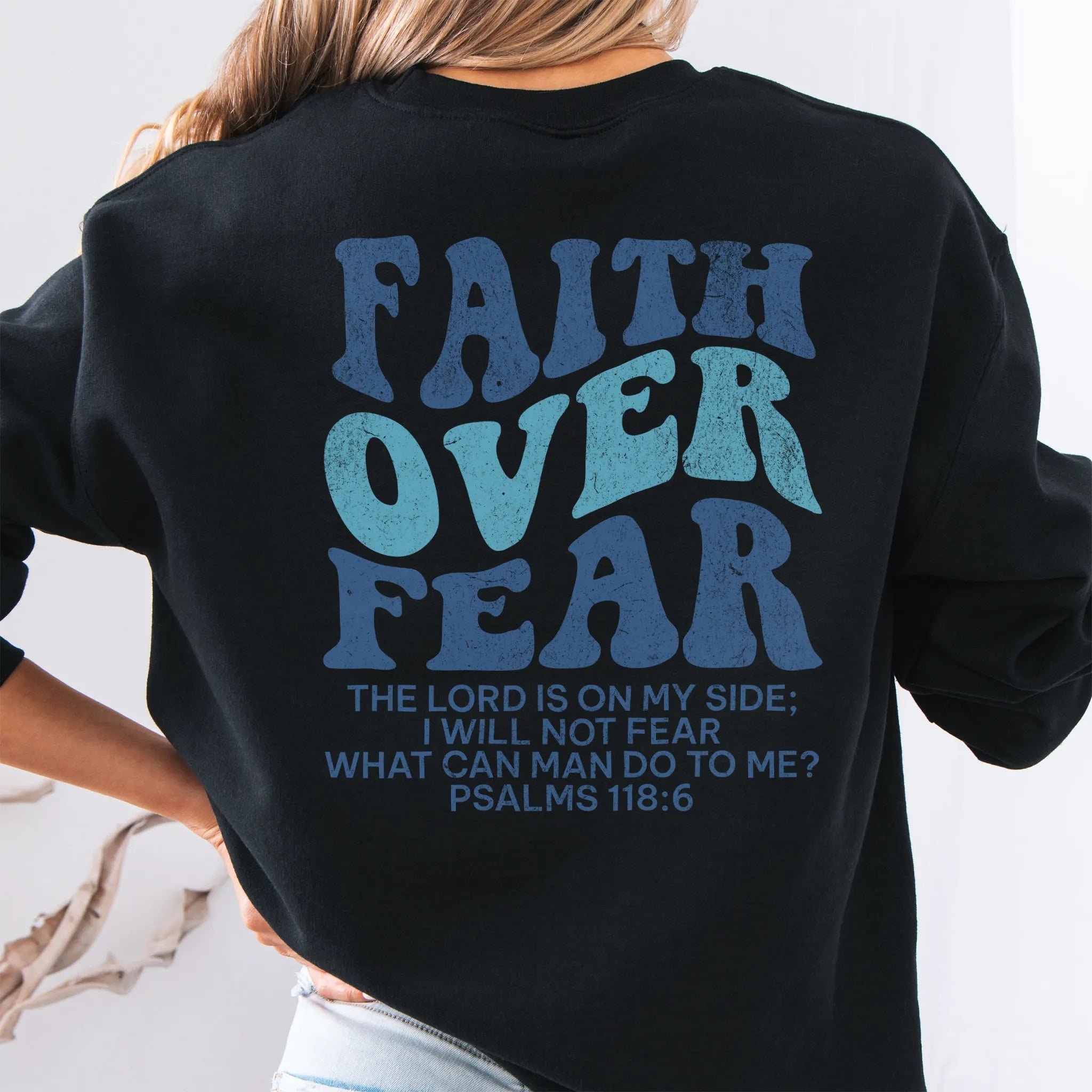 Black Oakley June sweatshirt, large back lettering reads Faith Over Fear with supporting scripture lines, studio back view