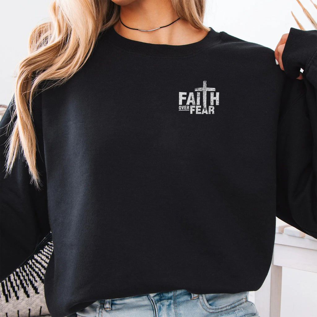Black Oakley June sweatshirt, left chest badge reads Faith Over Fear with small cross, relaxed modern fit, studio front view