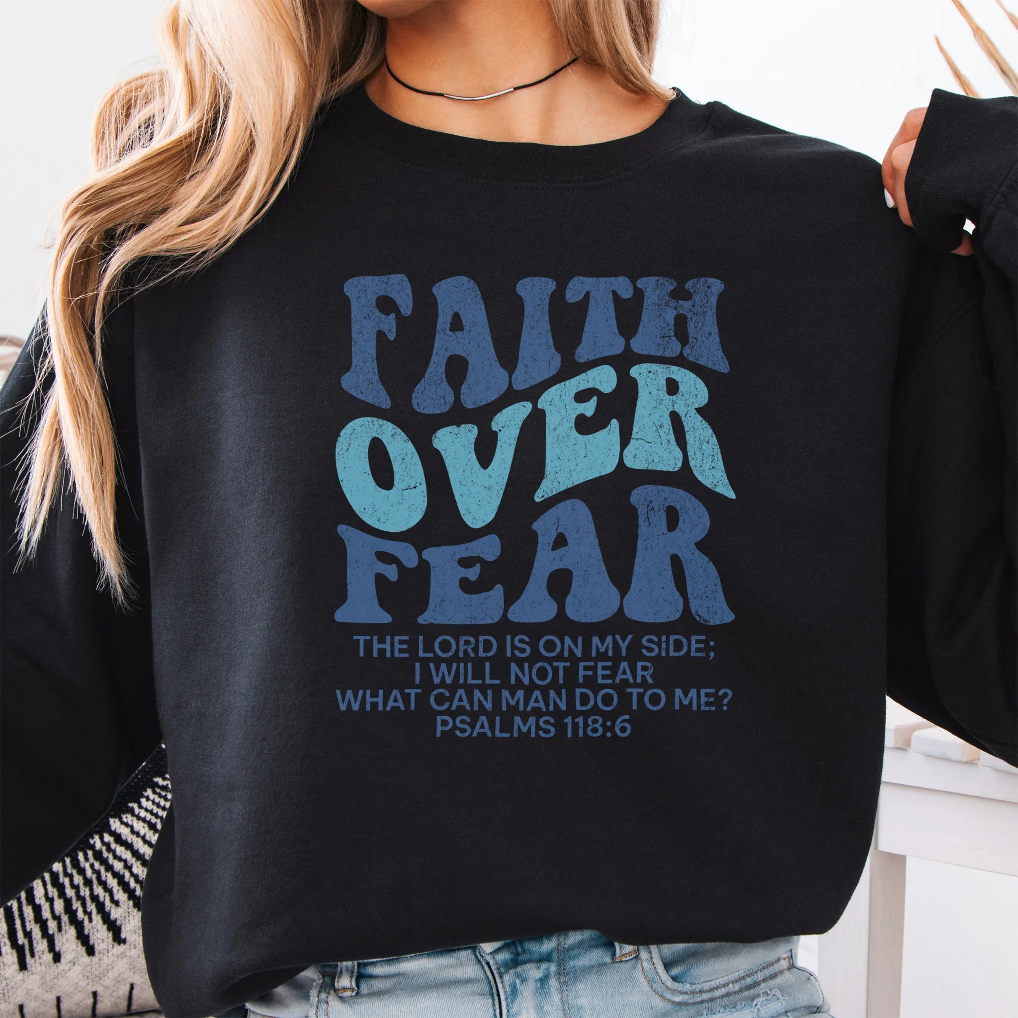 Black Oakley June sweatshirt, large front lettering reads Faith Over Fear with supporting lines The Lord Is On My Side I Will Not Fear What Can Man Do To Me, studio front view
