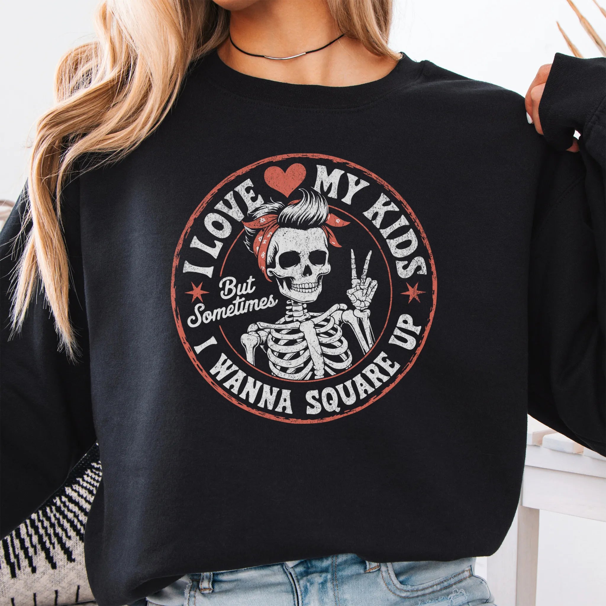 Black sweatshirt – large front circle graphic with skeleton mom giving a peace sign, headline reads “I Love My Kids But Sometimes I Wanna Square Up”, studio front view