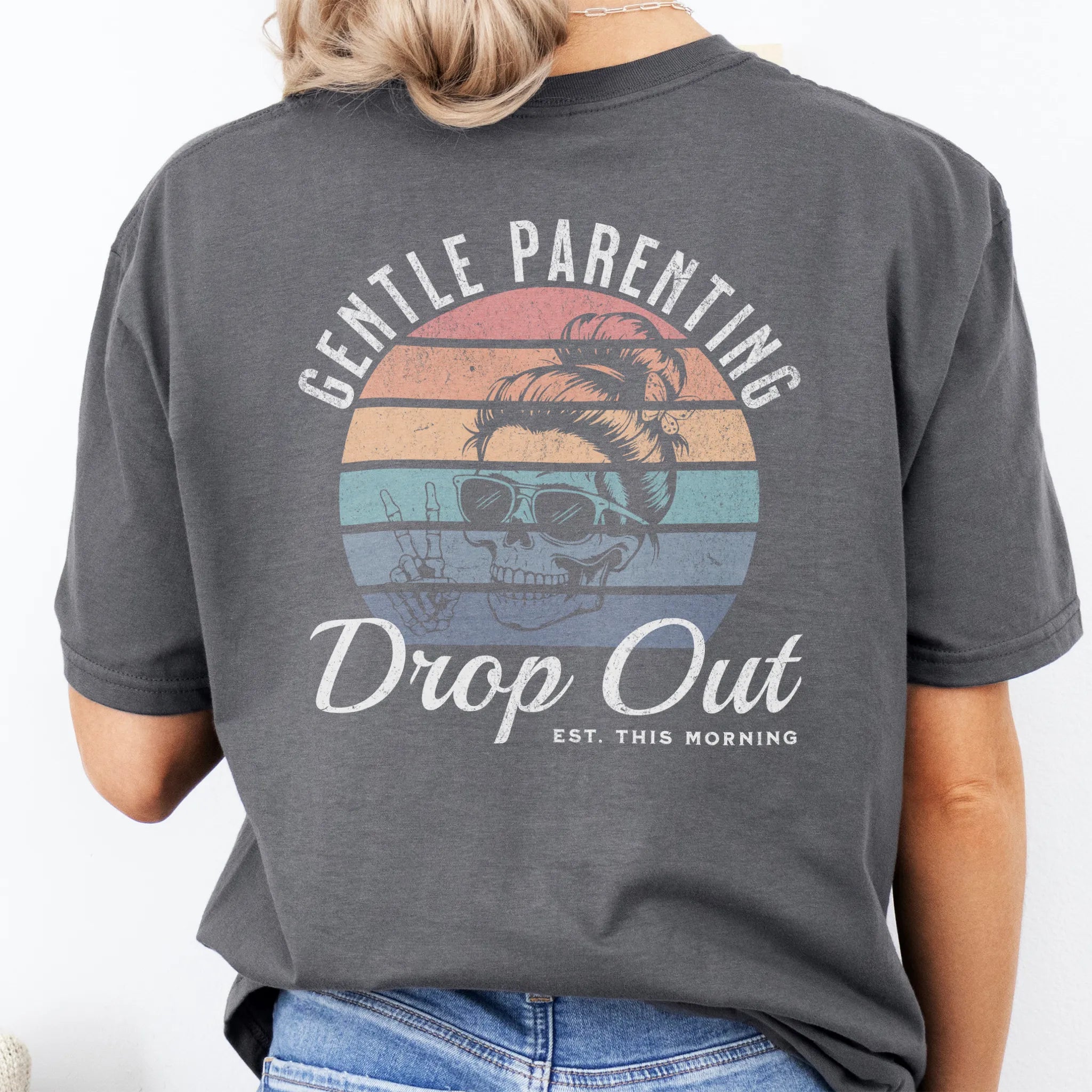 Charcoal Oakley June T Shirt back view Gentle Parenting Drop Out large round retro badge skull with messy bun wearing sunglasses peace sign script Est This Morning distressed print