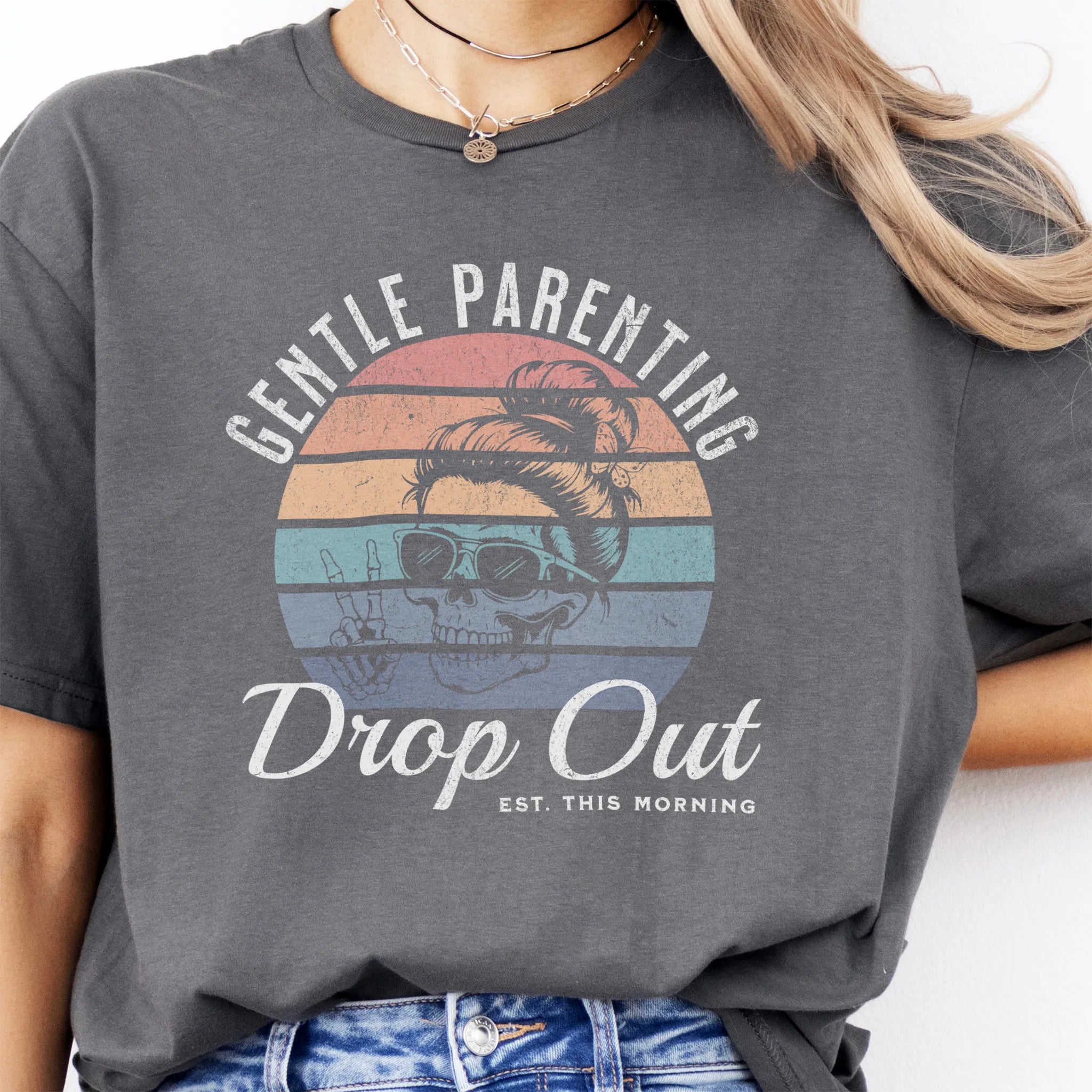 Charcoal Oakley June T Shirt front view Gentle Parenting Drop Out large chest graphic skull with messy bun sunglasses peace sign round retro stripe badge text Est This Morning distressed print