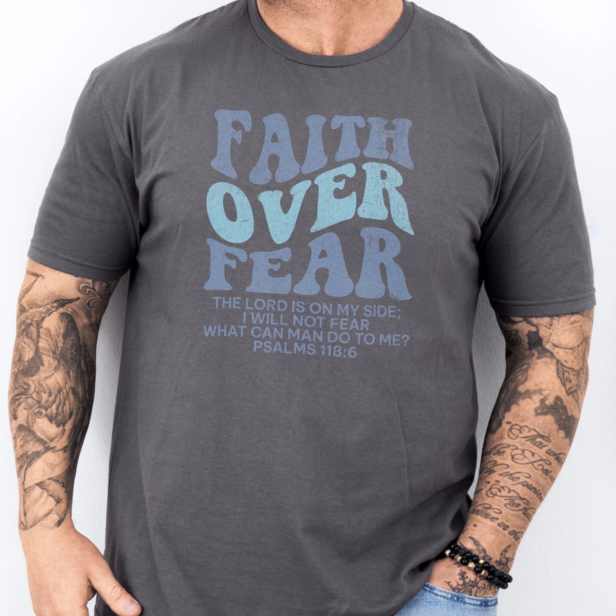 Charcoal Oakley June t shirt, mens fit, large front lettering reads Faith Over Fear with supporting lines The Lord Is On My Side I Will Not Fear What Can Man Do To Me, studio front view
