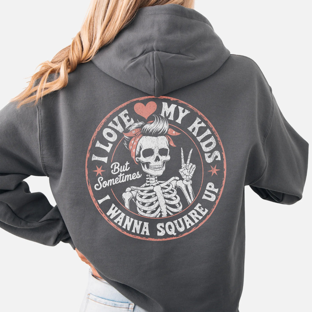 Charcoal Oakley June hoodie, large back circle graphic with skeleton mom giving a peace sign, text reads I Love My Kids But Sometimes I Wanna Square Up, studio back view