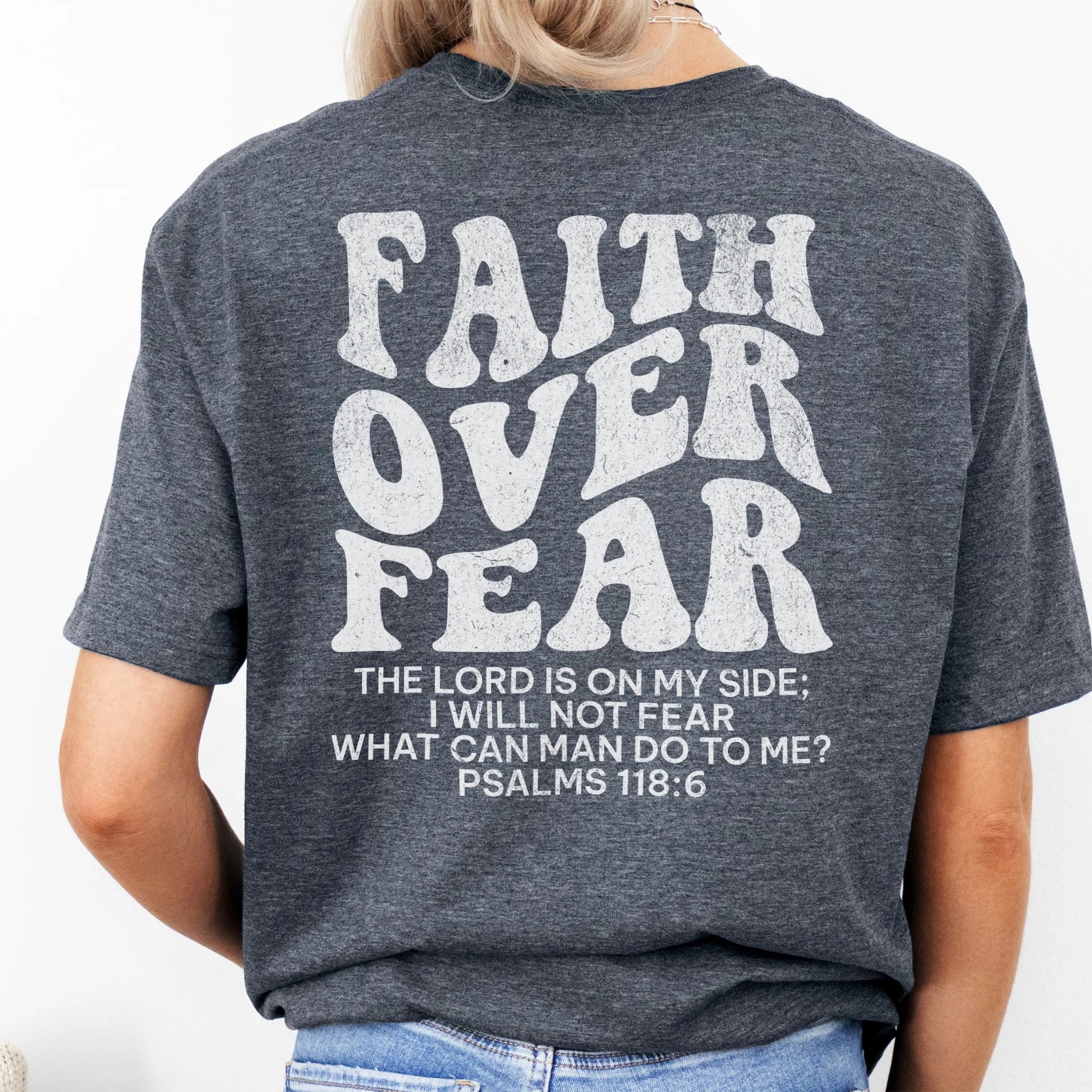 Dark Heather Oakley June t shirt, large back lettering reads Faith Over Fear with supporting scripture reference Psalms one eighteen six, studio back view