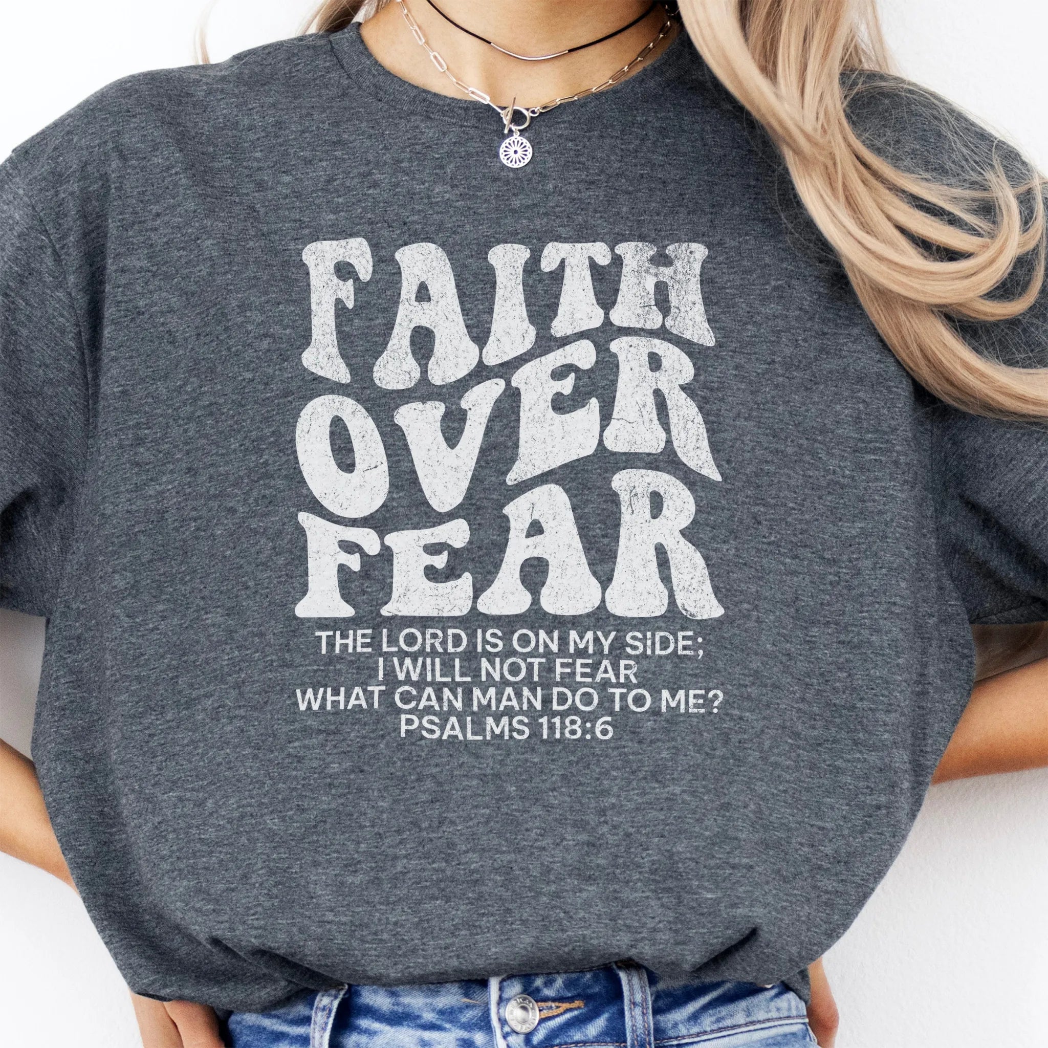 Dark Heather Oakley June t shirt, large front lettering reads Faith Over Fear with supporting lines The Lord Is On My Side I Will Not Fear What Can Man Do To Me, studio front view