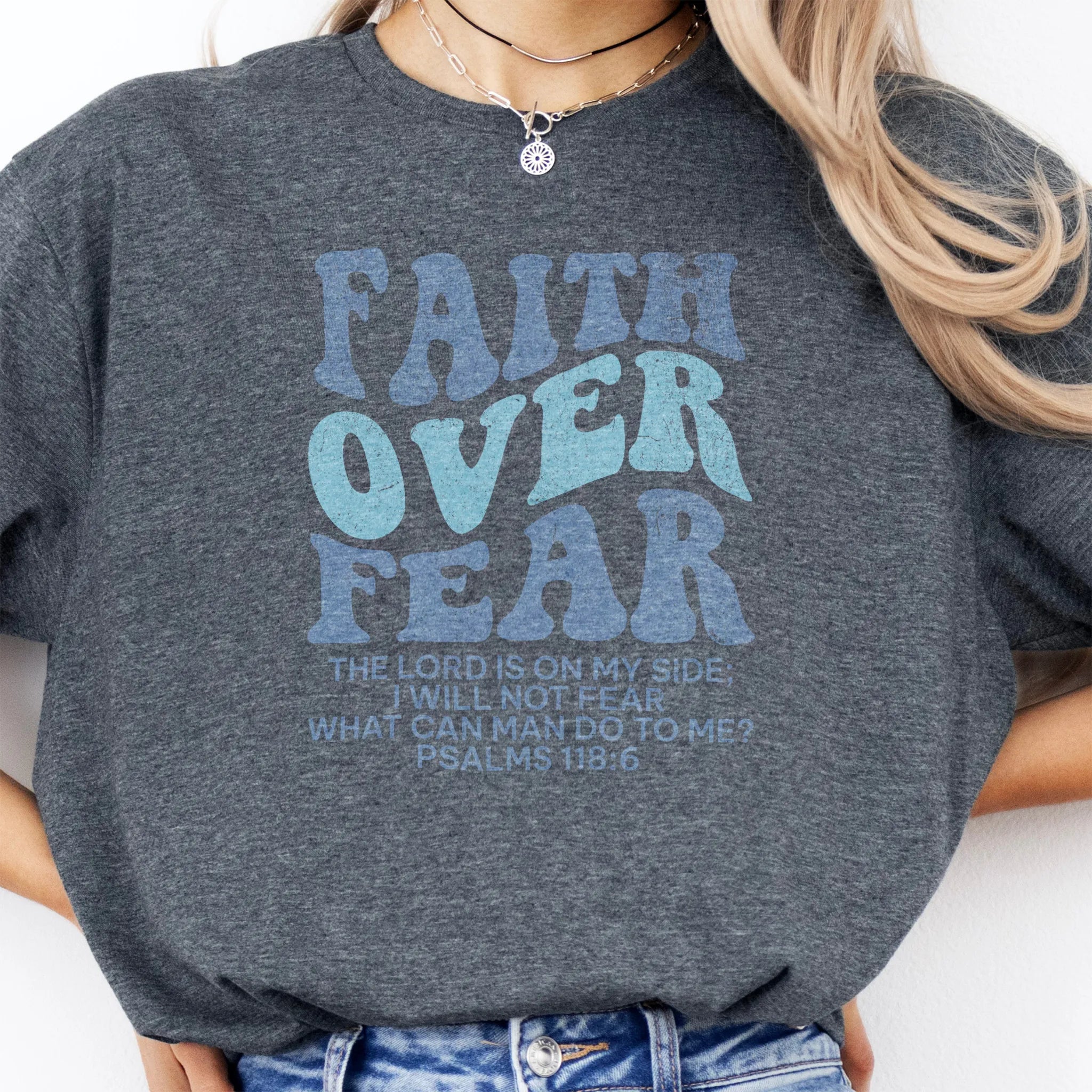 Dark Heather Oakley June t shirt, large front lettering reads Faith Over Fear with supporting lines The Lord Is On My Side I Will Not Fear What Can Man Do To Me, studio front view