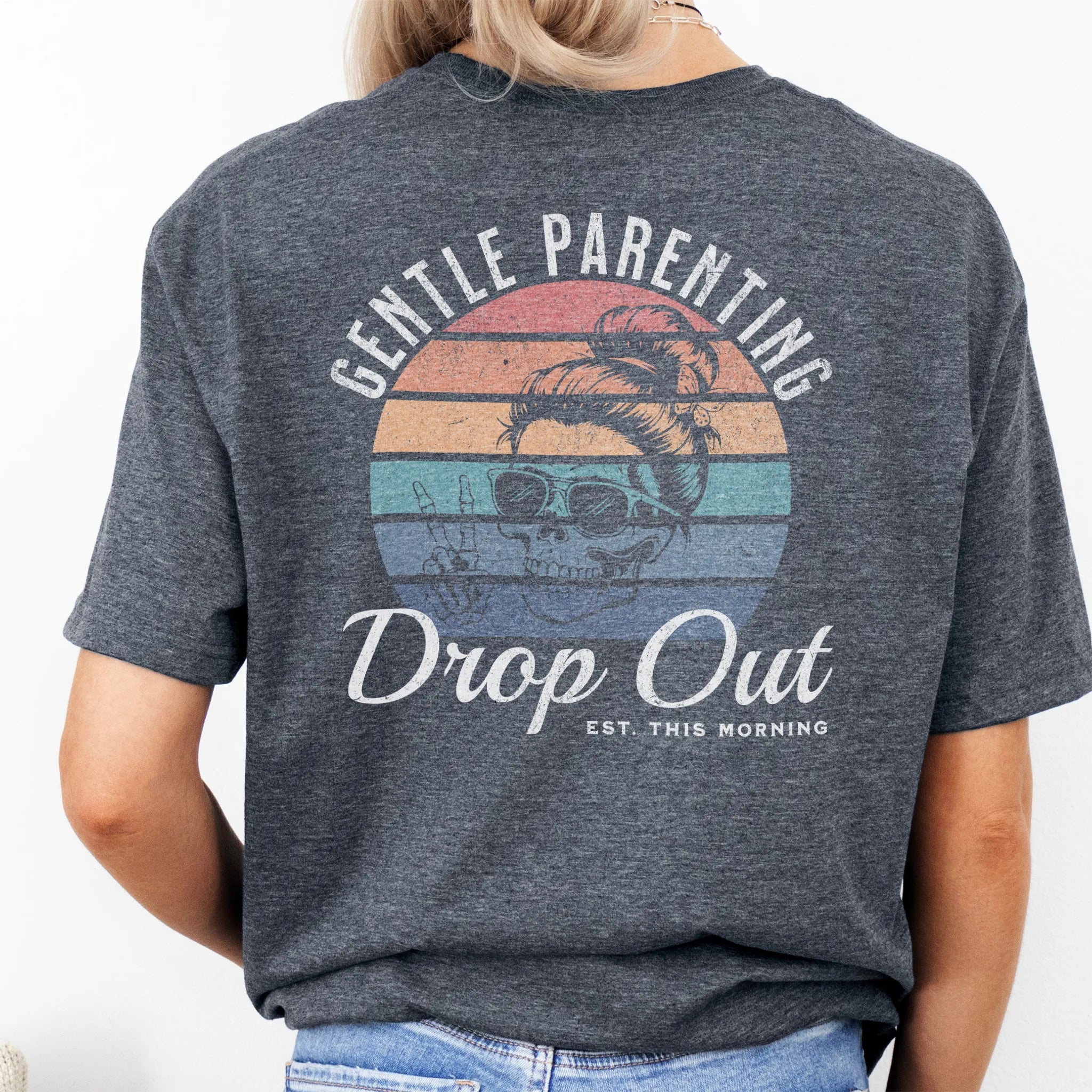 Dark Heather Oakley June T Shirt back view Gentle Parenting Drop Out large round retro badge skull with messy bun wearing sunglasses peace sign script Est This Morning distressed print
