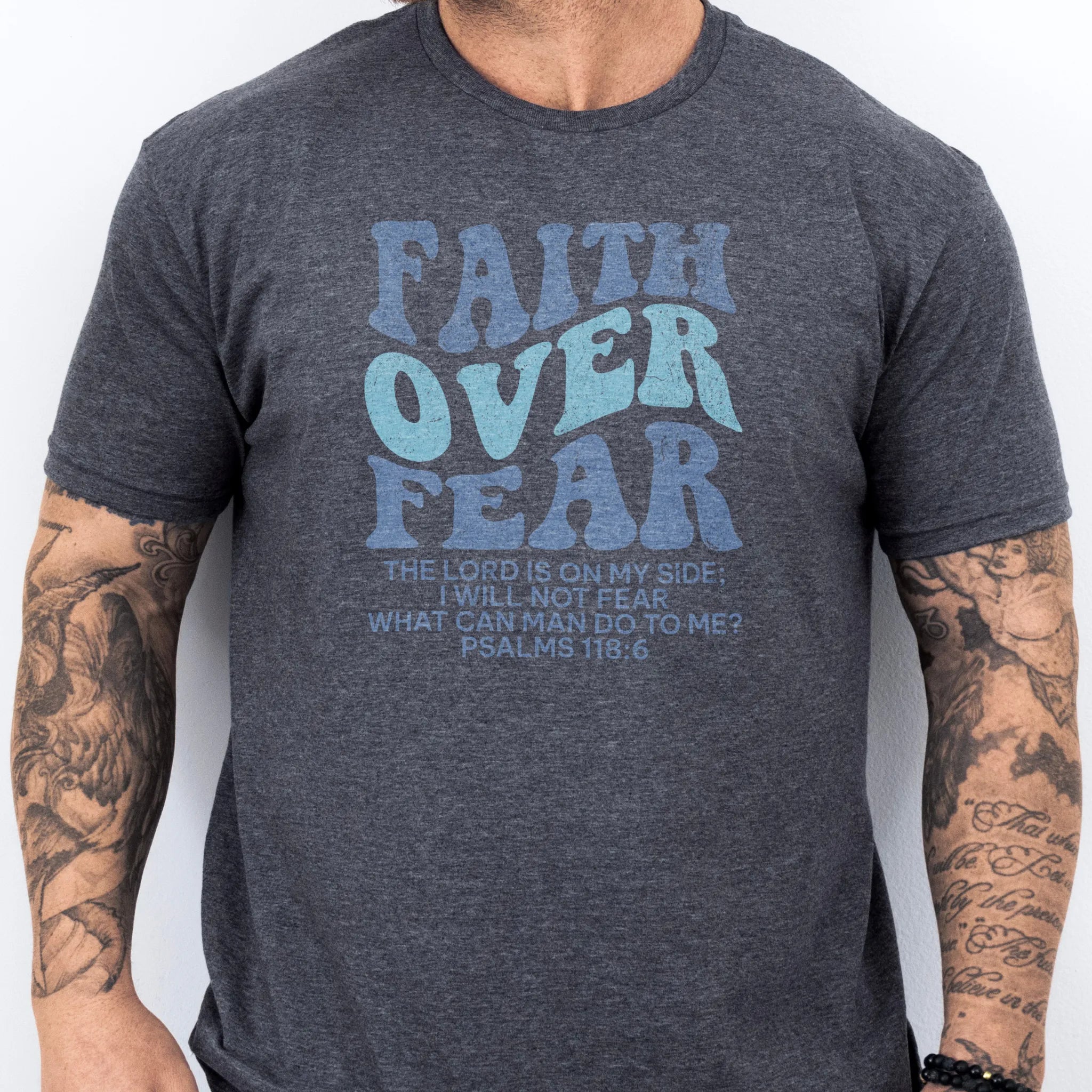 Dark Heather Oakley June t shirt, mens fit, large front lettering reads Faith Over Fear with supporting lines The Lord Is On My Side I Will Not Fear What Can Man Do To Me, studio front view
