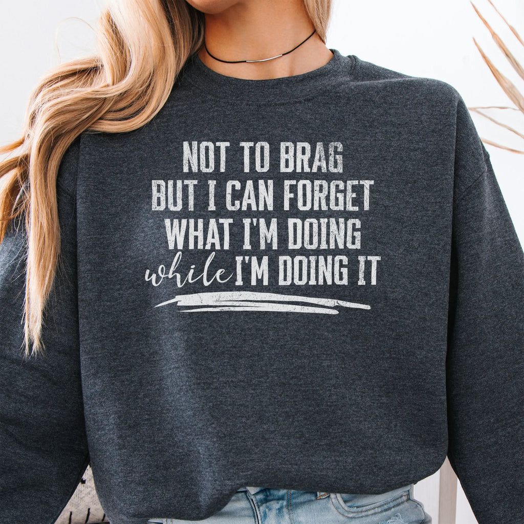 Dark Heather Oakley June Sweatshirt front view large text Not To Brag But I Can Forget What I’m Doing While I’m Doing It underline distressed print