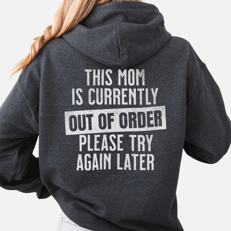 Dark Heather hoodie – large back text reads “This Mom Is Currently Out of Order, Please Try Again Later”, relaxed modern fit with hood up, studio back view