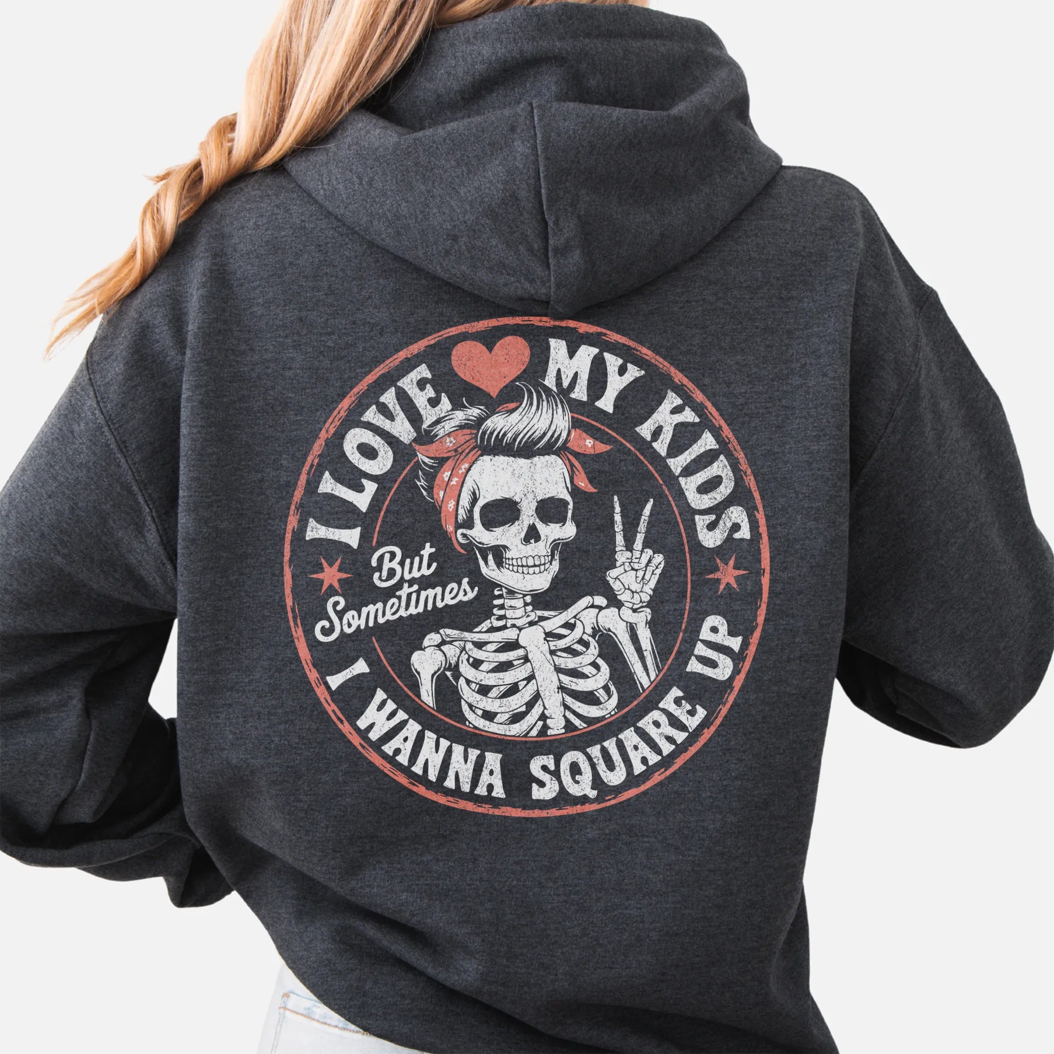 Dark Heather Oakley June hoodie, large back circle graphic with skeleton mom giving a peace sign, text reads I Love My Kids But Sometimes I Wanna Square Up, studio back view
