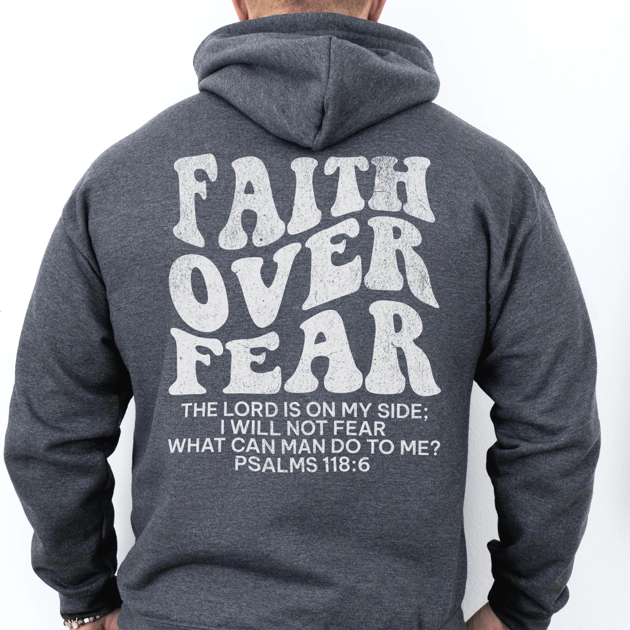 Dark Heather Oakley June hoodie, mens fit, large back lettering reads Faith Over Fear with supporting scripture lines, studio back view