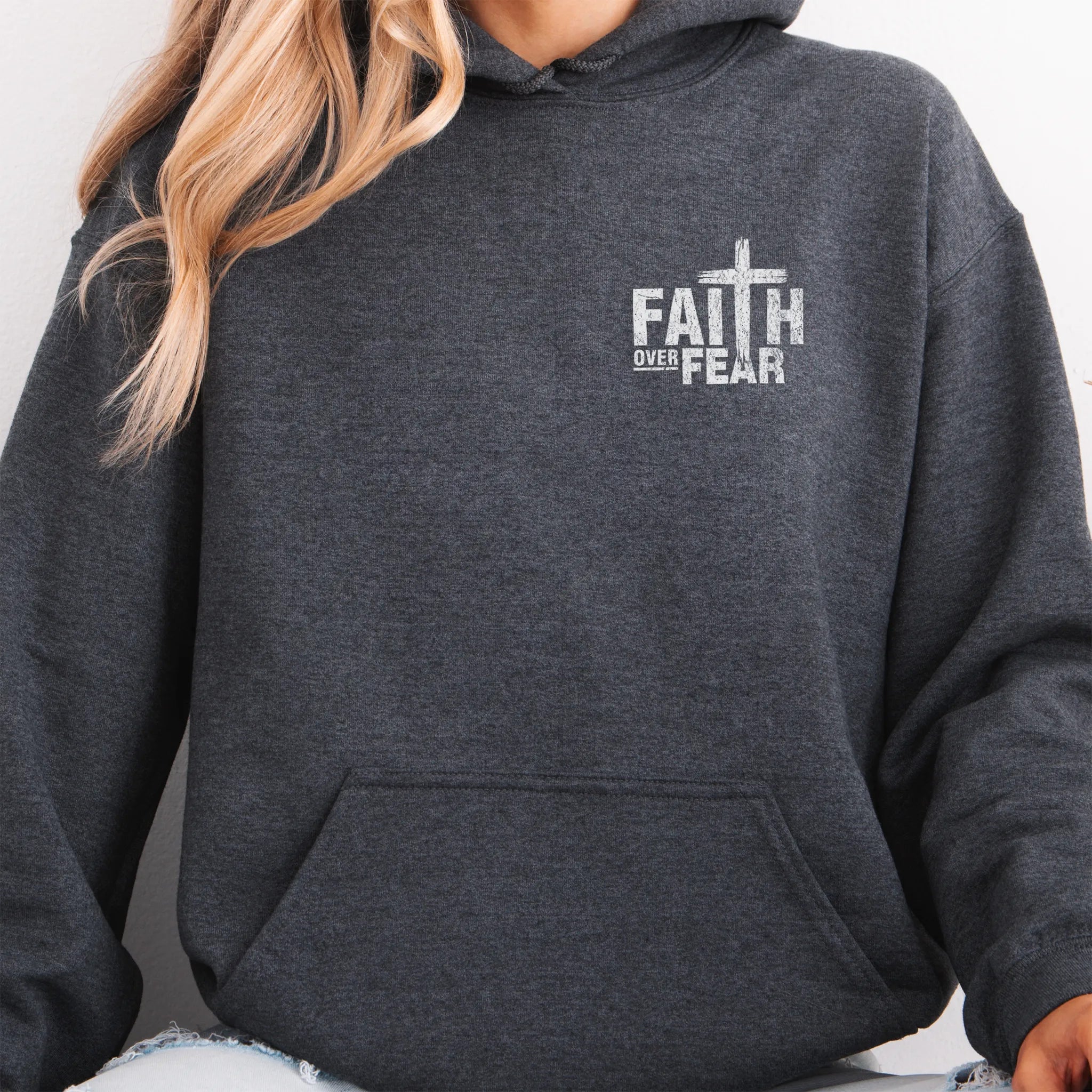 Dark Heather Oakley June hoodie, left chest badge reads Faith Over Fear with small cross, kangaroo pocket and relaxed modern fit, studio front view