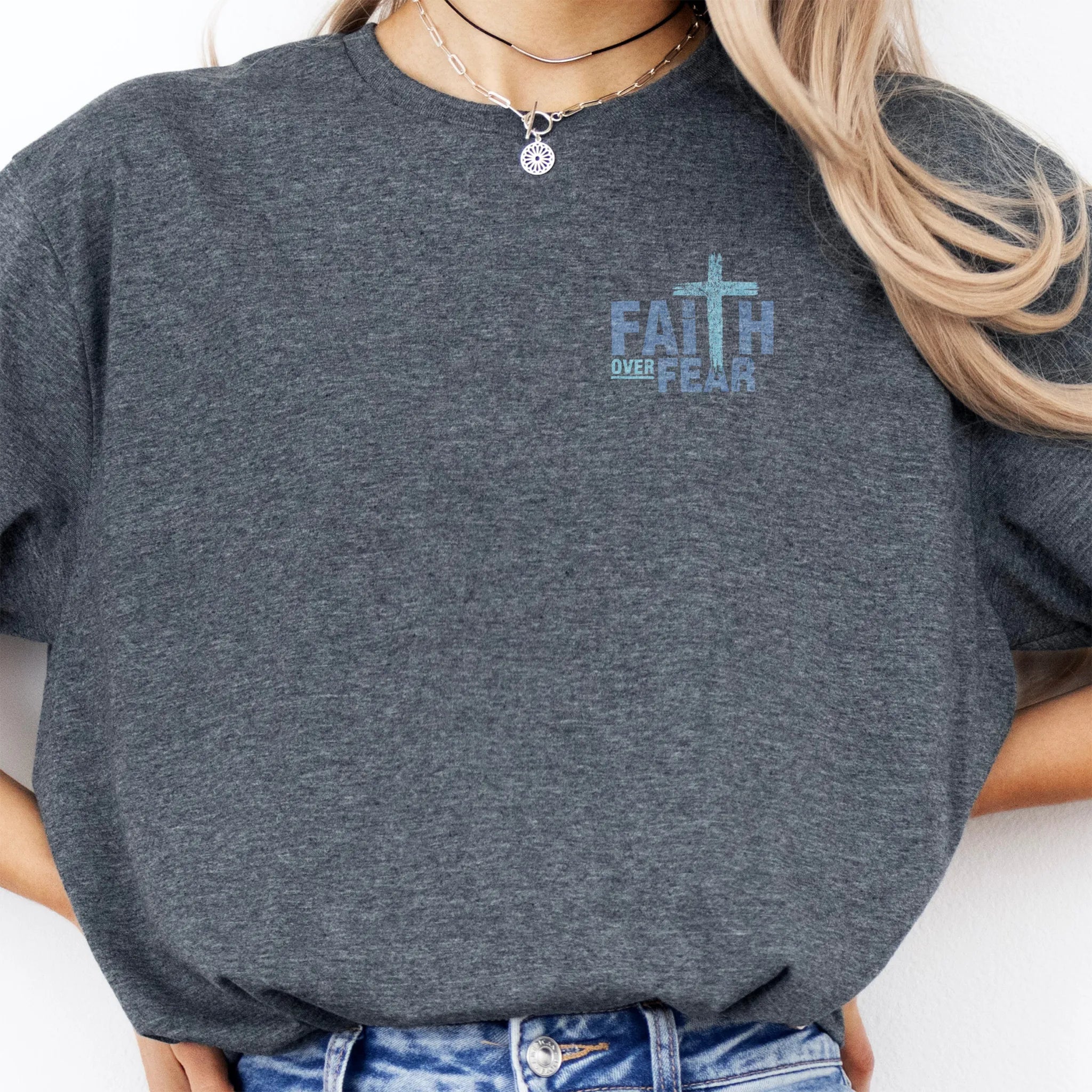 Dark Heather Oakley June t shirt, left chest badge reads Faith Over Fear with small cross, relaxed modern fit, studio front view