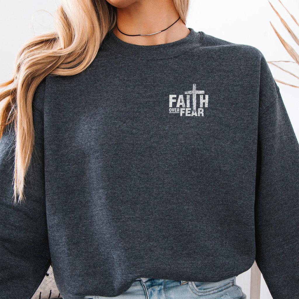 Dark Heather Oakley June sweatshirt, left chest badge reads Faith Over Fear with small cross, relaxed modern fit, studio front view