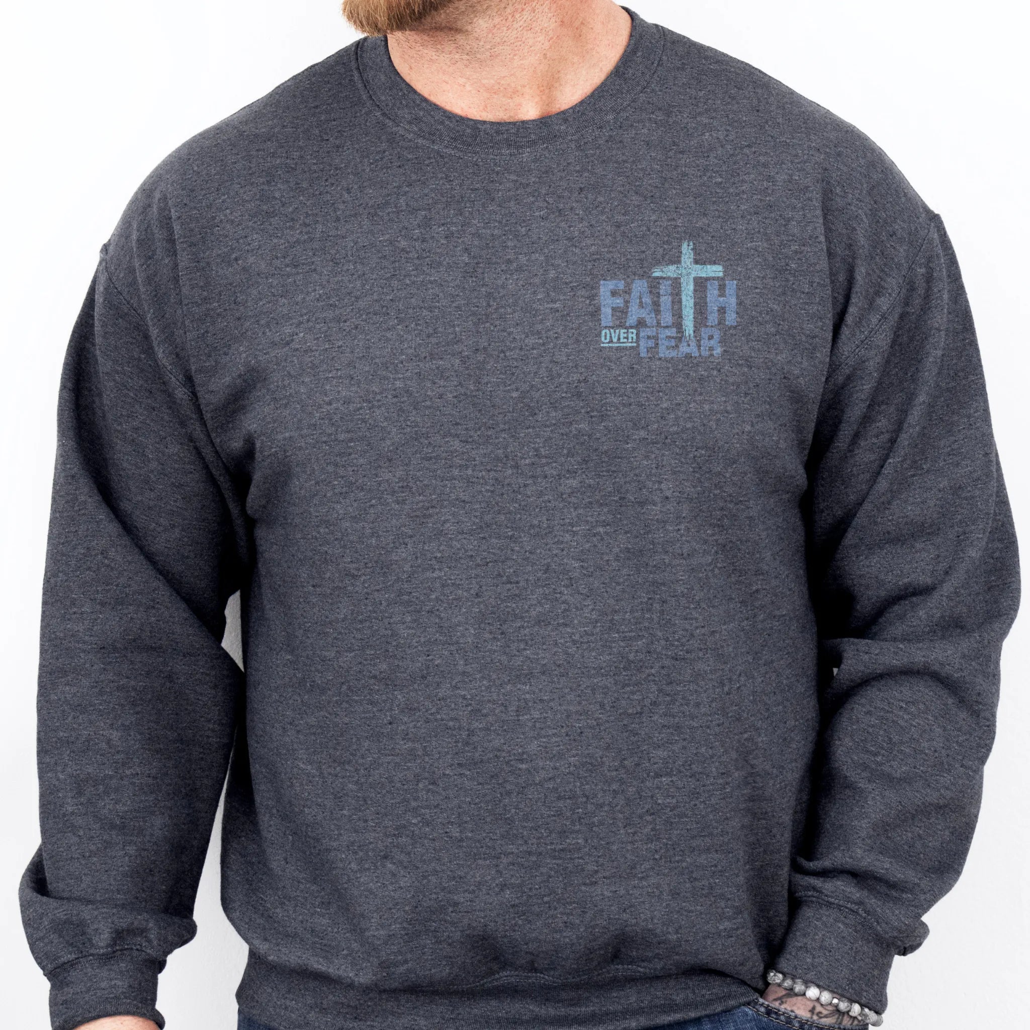 Dark Heather Oakley June sweatshirt, mens fit, left chest badge reads Faith Over Fear with small cross, studio front view