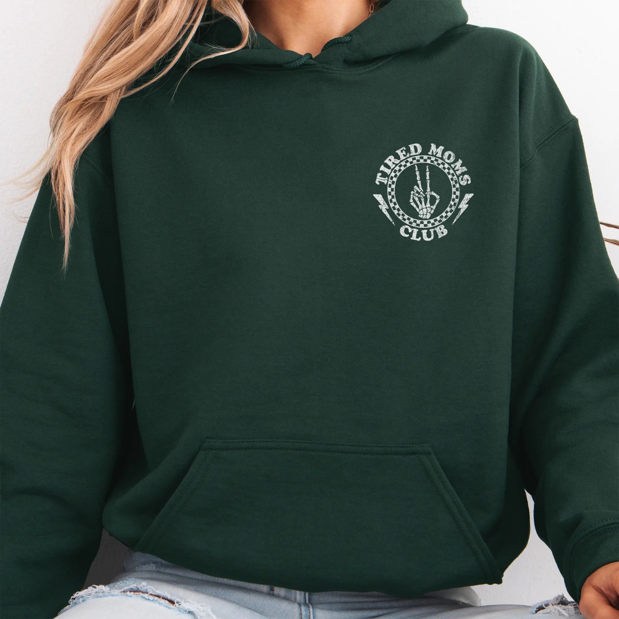 Forest Green Oakley June Hoodie front view small left chest Tired Moms Club badge crest kangaroo pocket drawstrings visible distressed print