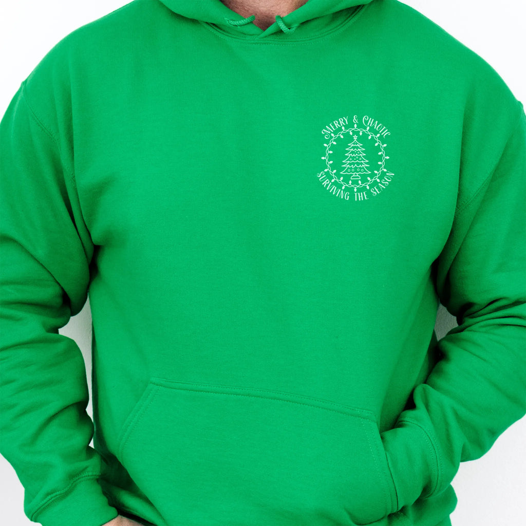 Irish Green men’s hoodie left chest badge text “Merry & Chaotic — Surviving the Season”