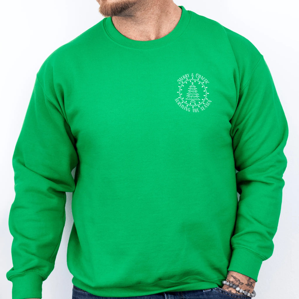 Irish Green men’s sweatshirt left chest badge text “Merry & Chaotic — Surviving the Season”