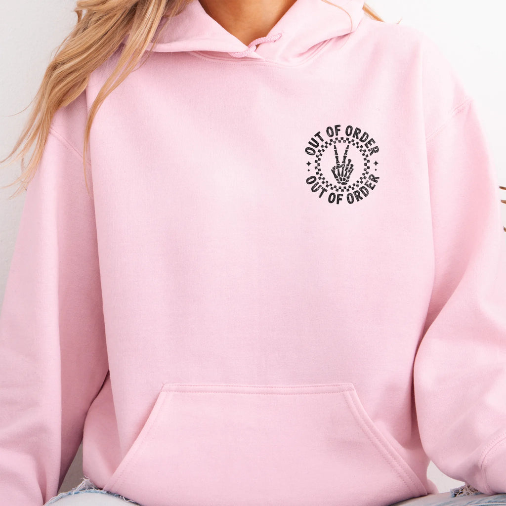 Light Pink hoodie – left chest circular badge with “Out of Order” text, kangaroo pocket and relaxed modern fit, studio front view