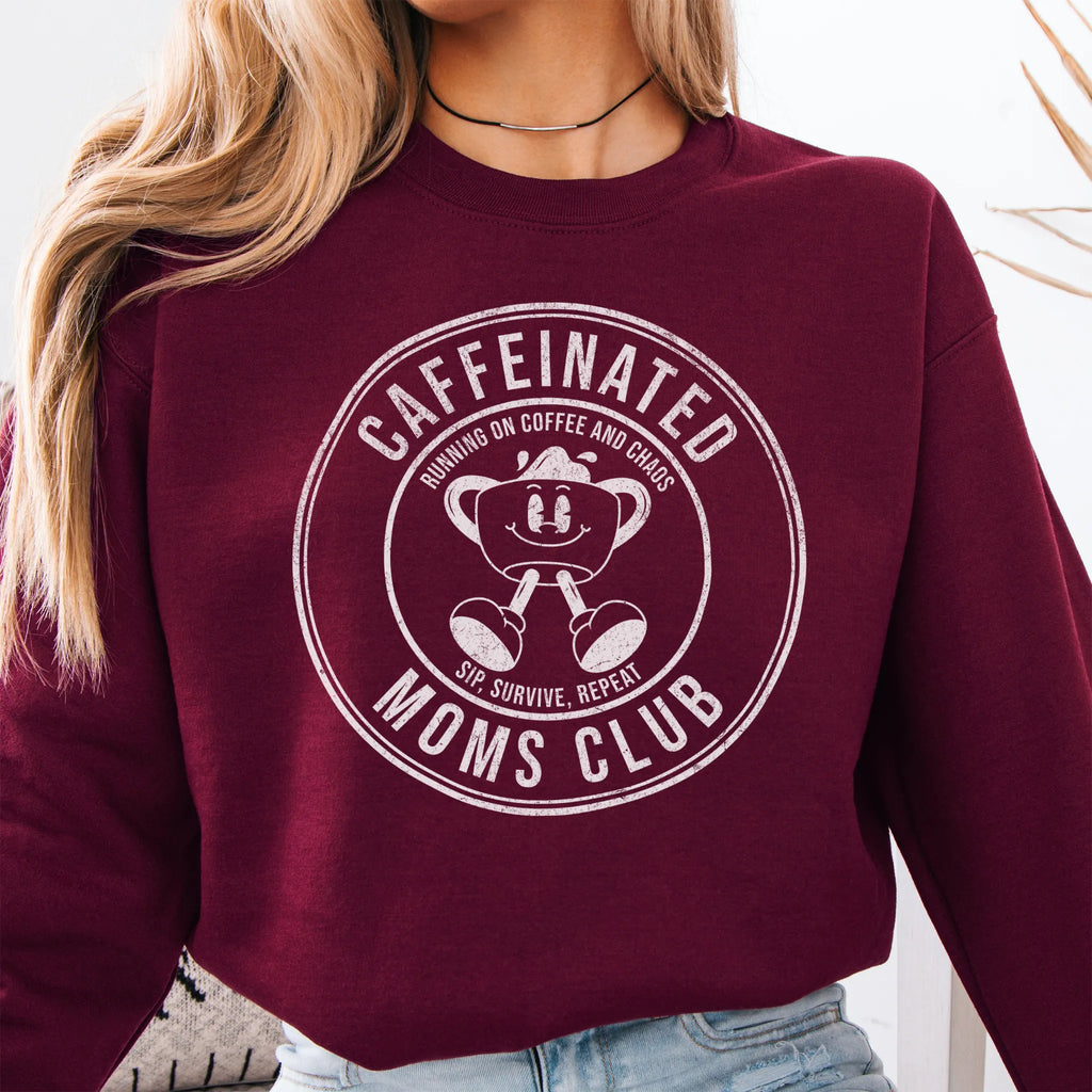 Maroon Oakley June Sweatshirt front view large Caffeinated Moms Club circle badge coffee cup mascot text Running on Coffee and Chaos Sip Survive Repeat mono black ink distressed