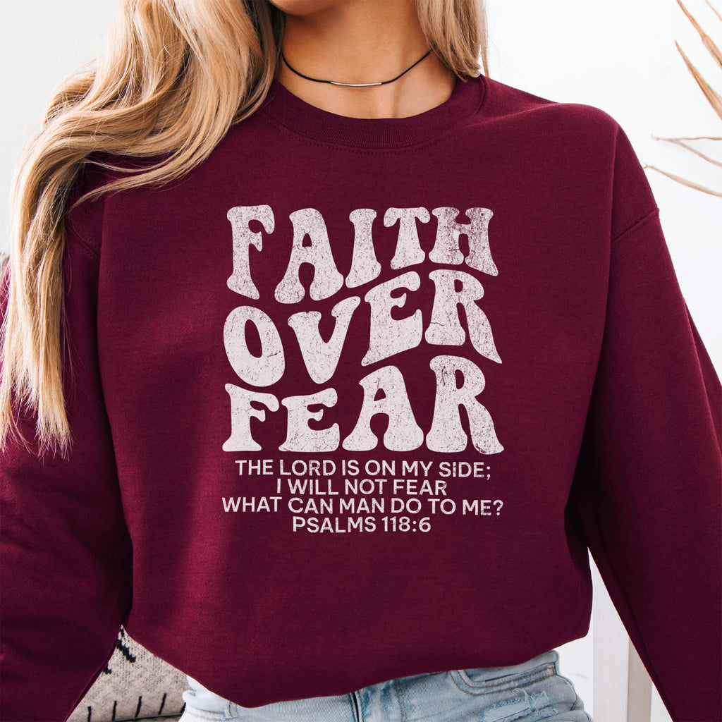 Maroon Oakley June sweatshirt, large front lettering reads Faith Over Fear with supporting lines The Lord Is On My Side I Will Not Fear What Can Man Do To Me, studio front view