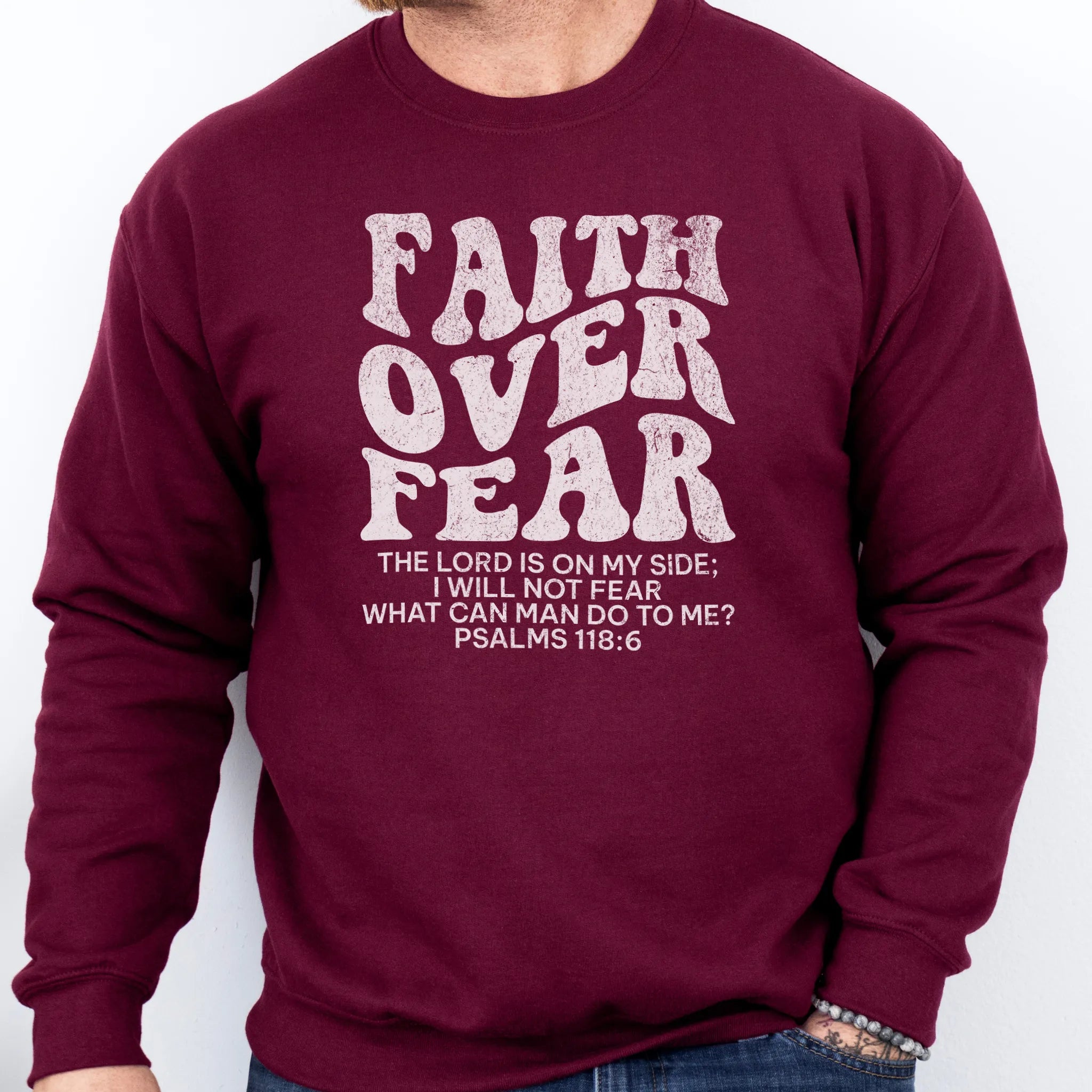 Maroon Oakley June sweatshirt, mens fit, left chest badge reads Faith Over Fear with cross, studio front view