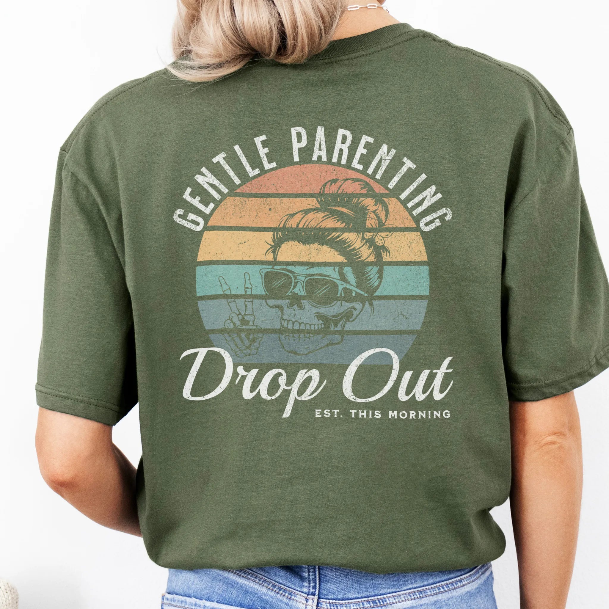 Military Green Oakley June T Shirt back view Gentle Parenting Drop Out large round retro badge skull with messy bun wearing sunglasses peace sign script Est This Morning distressed print