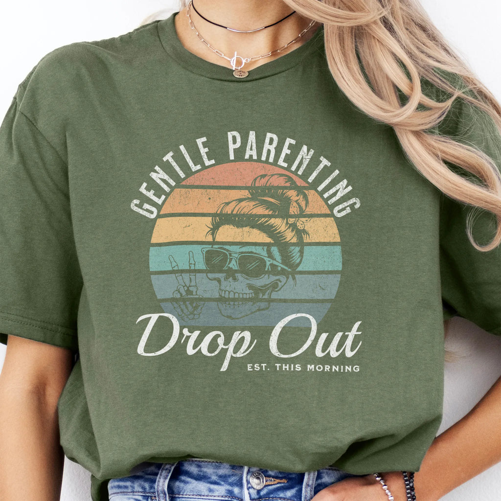 Military Green Oakley June T Shirt front view Gentle Parenting Drop Out large chest graphic skull with messy bun sunglasses peace sign round retro stripe badge text Est This Morning distressed print