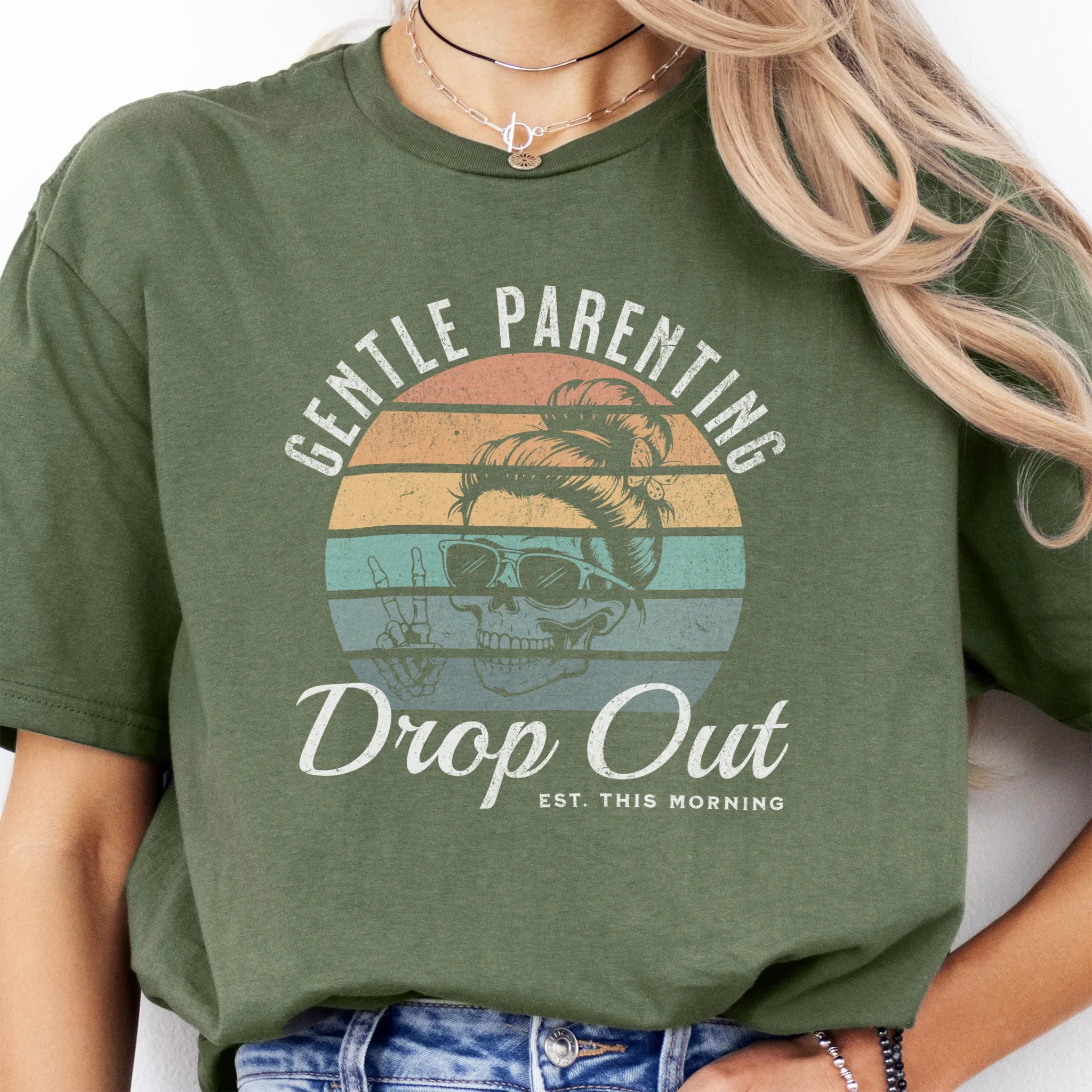 Military Green Oakley June T Shirt front view Gentle Parenting Drop Out large chest graphic skull with messy bun sunglasses peace sign round retro stripe badge text Est This Morning distressed print