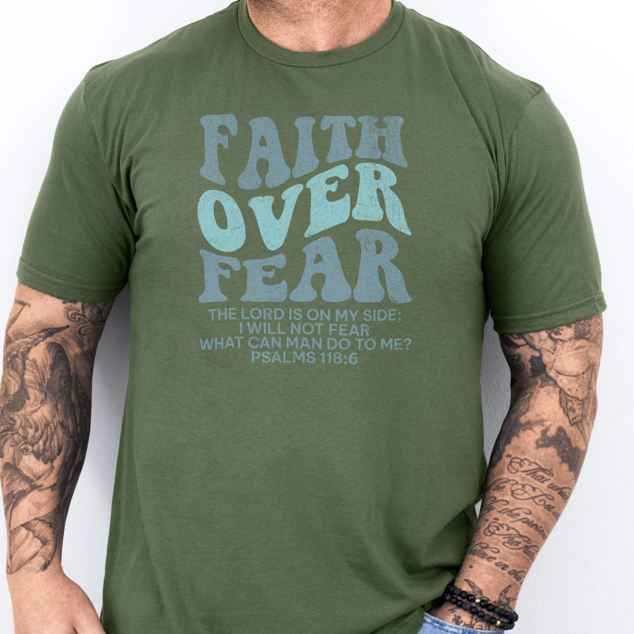 Military Green Oakley June t shirt, mens fit, large front lettering reads Faith Over Fear with supporting lines The Lord Is On My Side I Will Not Fear What Can Man Do To Me, studio front view