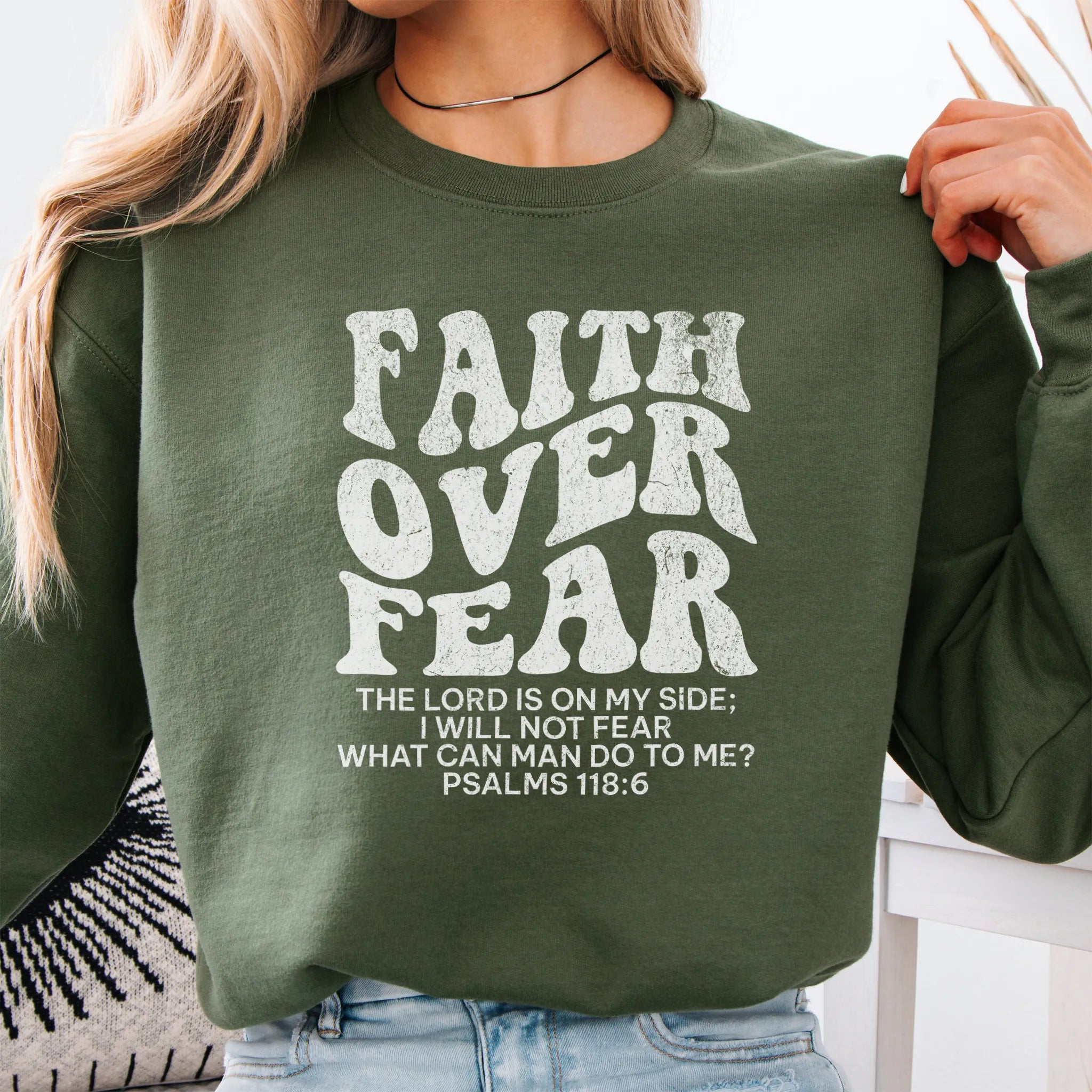 Military Green Oakley June sweatshirt, large front lettering reads Faith Over Fear with supporting lines The Lord Is On My Side I Will Not Fear What Can Man Do To Me, studio front view