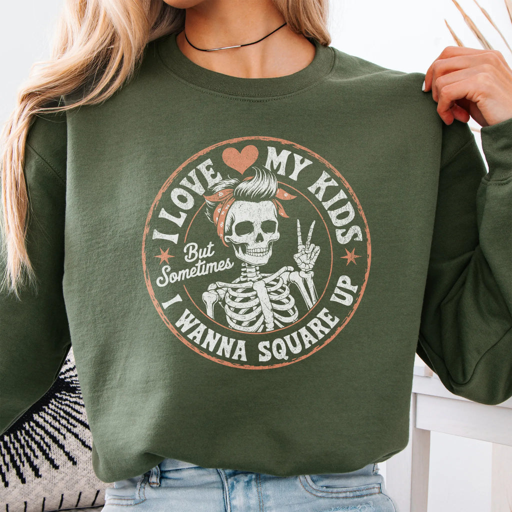 Military Green sweatshirt – large front circle graphic with skeleton mom giving a peace sign, headline reads “I Love My Kids But Sometimes I Wanna Square Up”, studio front view