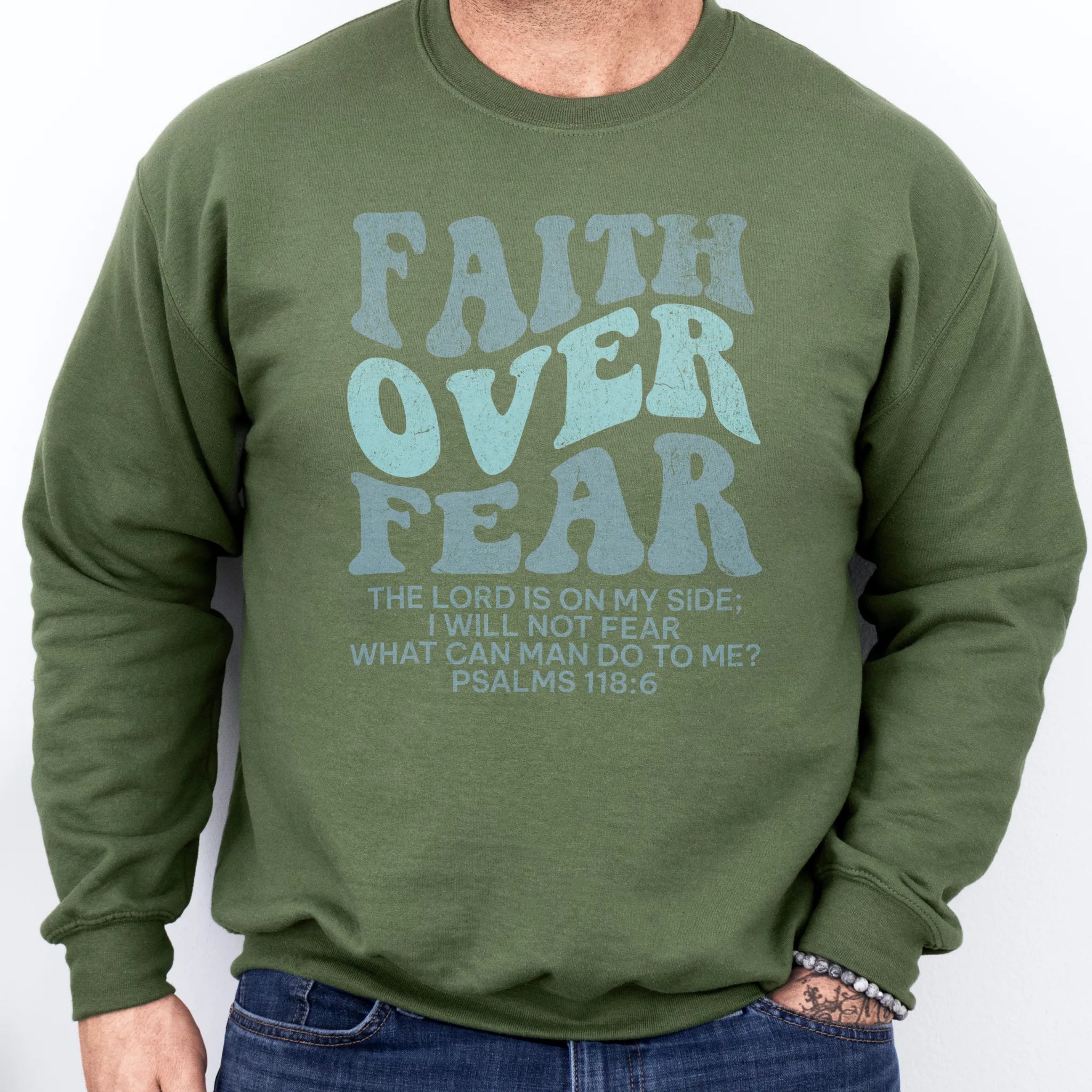 Military Green Oakley June sweatshirt, mens fit, large front lettering reads Faith Over Fear with supporting lines The Lord Is On My Side I Will Not Fear What Can Man Do To Me, studio front view