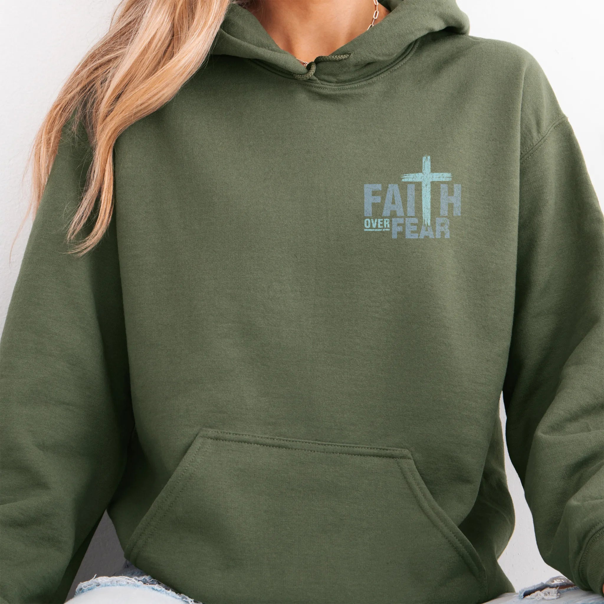 Military Green Oakley June hoodie, left chest badge reads Faith Over Fear with small cross, kangaroo pocket and relaxed modern fit, studio front view