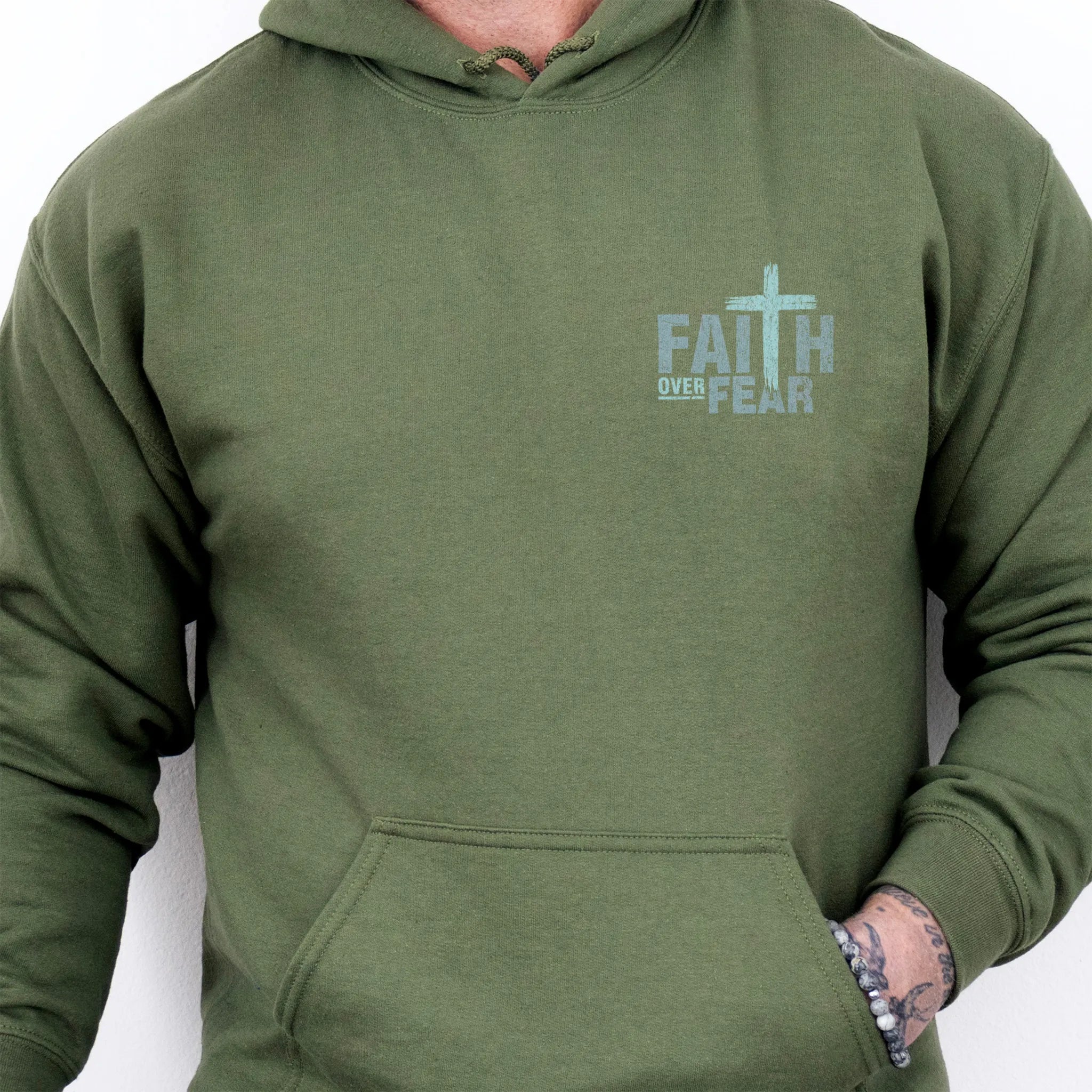 Military Green Oakley June hoodie, mens fit, left chest badge reads Faith Over Fear with cross, kangaroo pocket and relaxed modern fit, studio front view