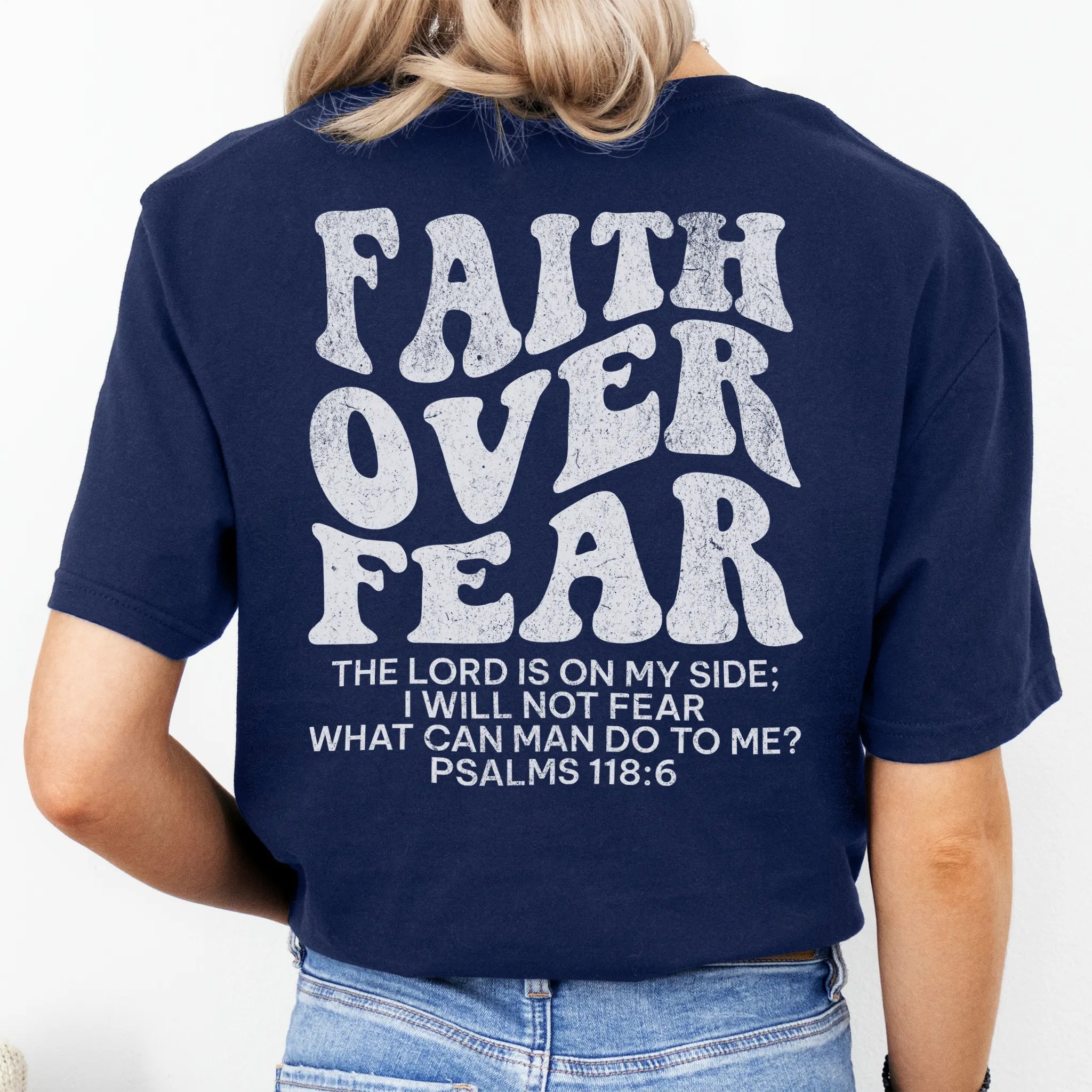 Navy Oakley June t shirt, large back lettering reads Faith Over Fear with supporting scripture reference Psalms one eighteen six, studio back view