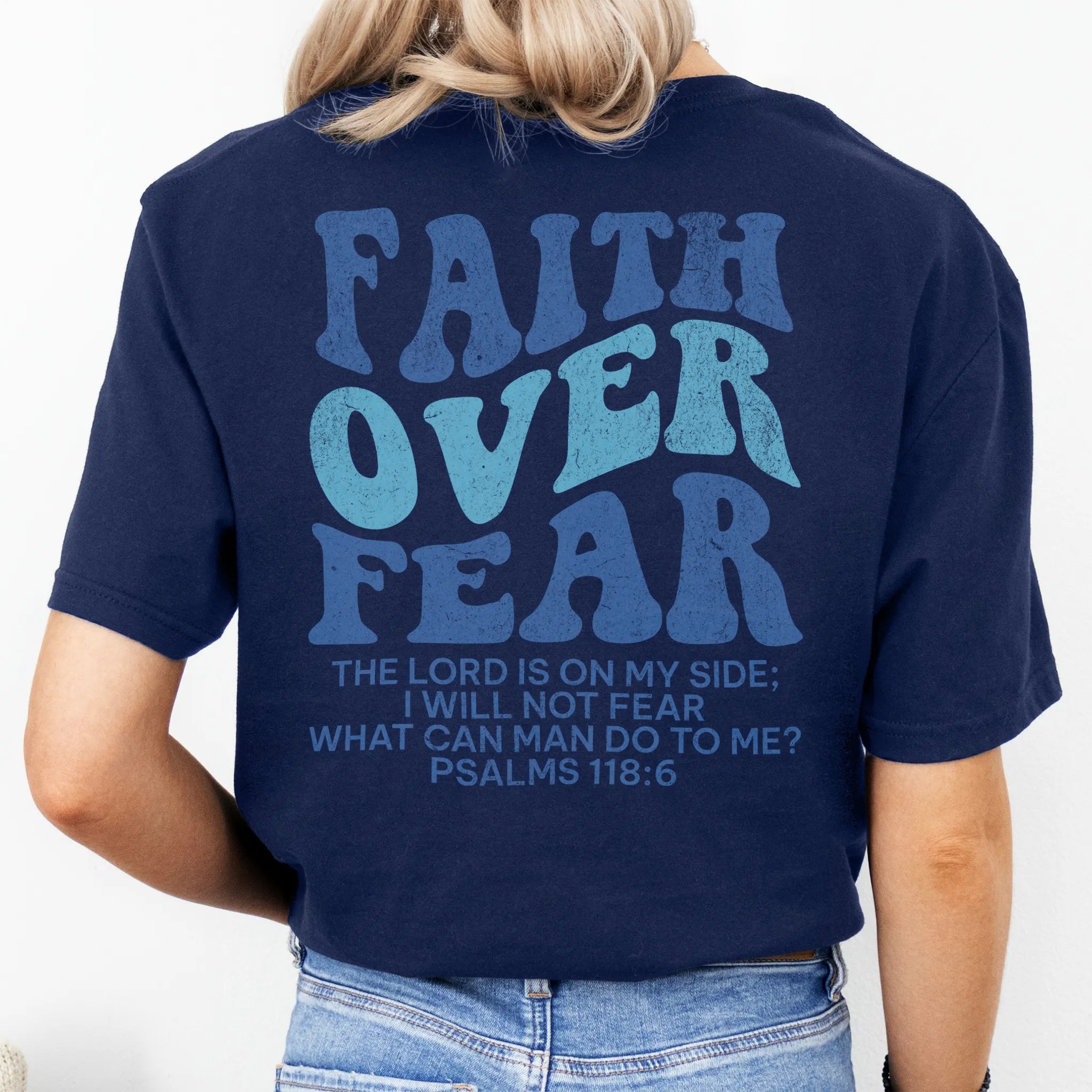 Navy Oakley June t shirt, large back lettering reads Faith Over Fear with supporting scripture lines, studio back view