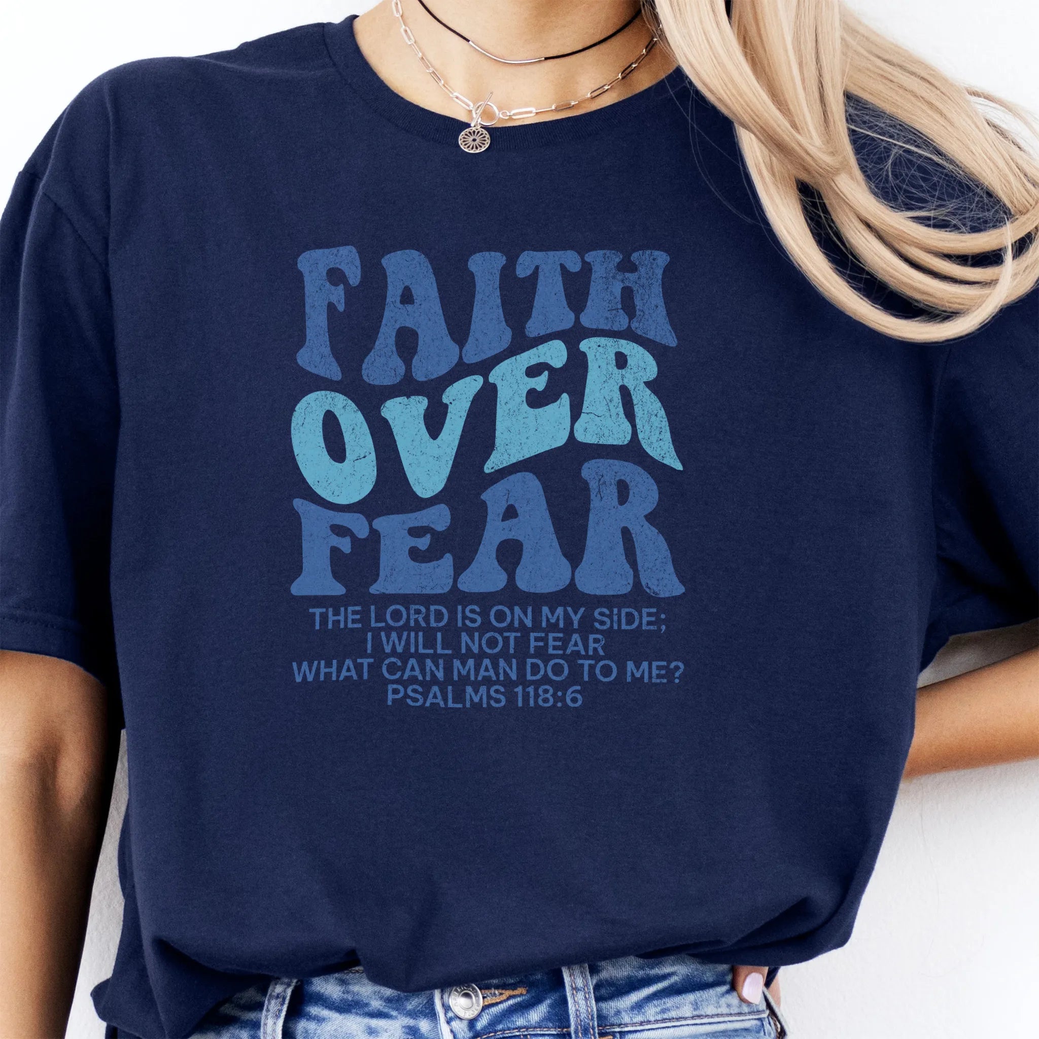 Navy Oakley June t shirt, large front lettering reads Faith Over Fear with supporting lines The Lord Is On My Side I Will Not Fear What Can Man Do To Me, studio front view