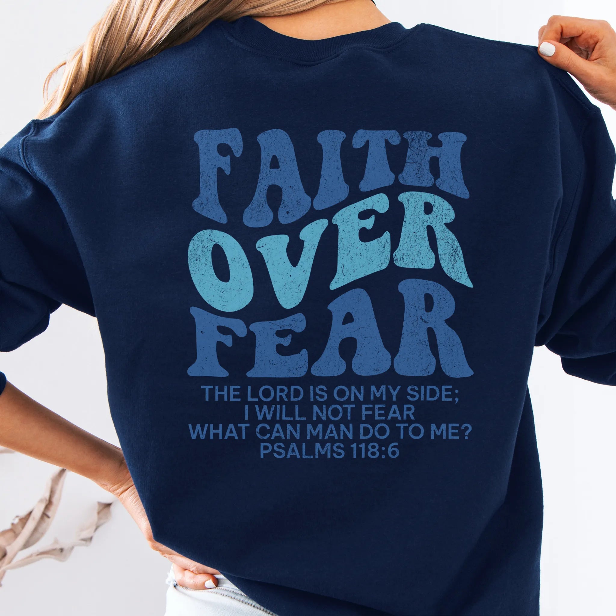 Navy Oakley June sweatshirt, large back lettering reads Faith Over Fear with supporting scripture lines, studio back view