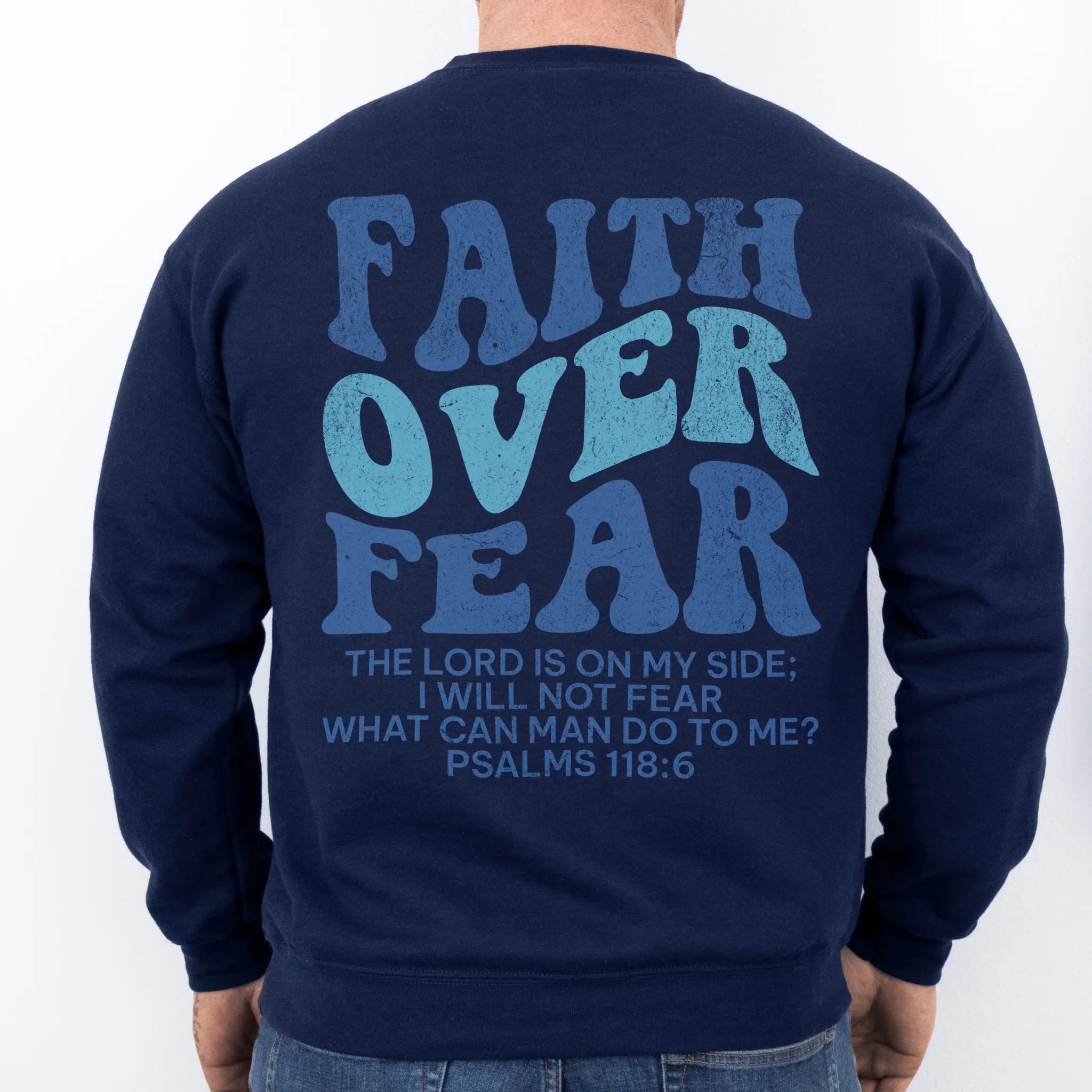 Navy Oakley June sweatshirt, mens fit, large back lettering reads Faith Over Fear with supporting scripture lines, studio back view