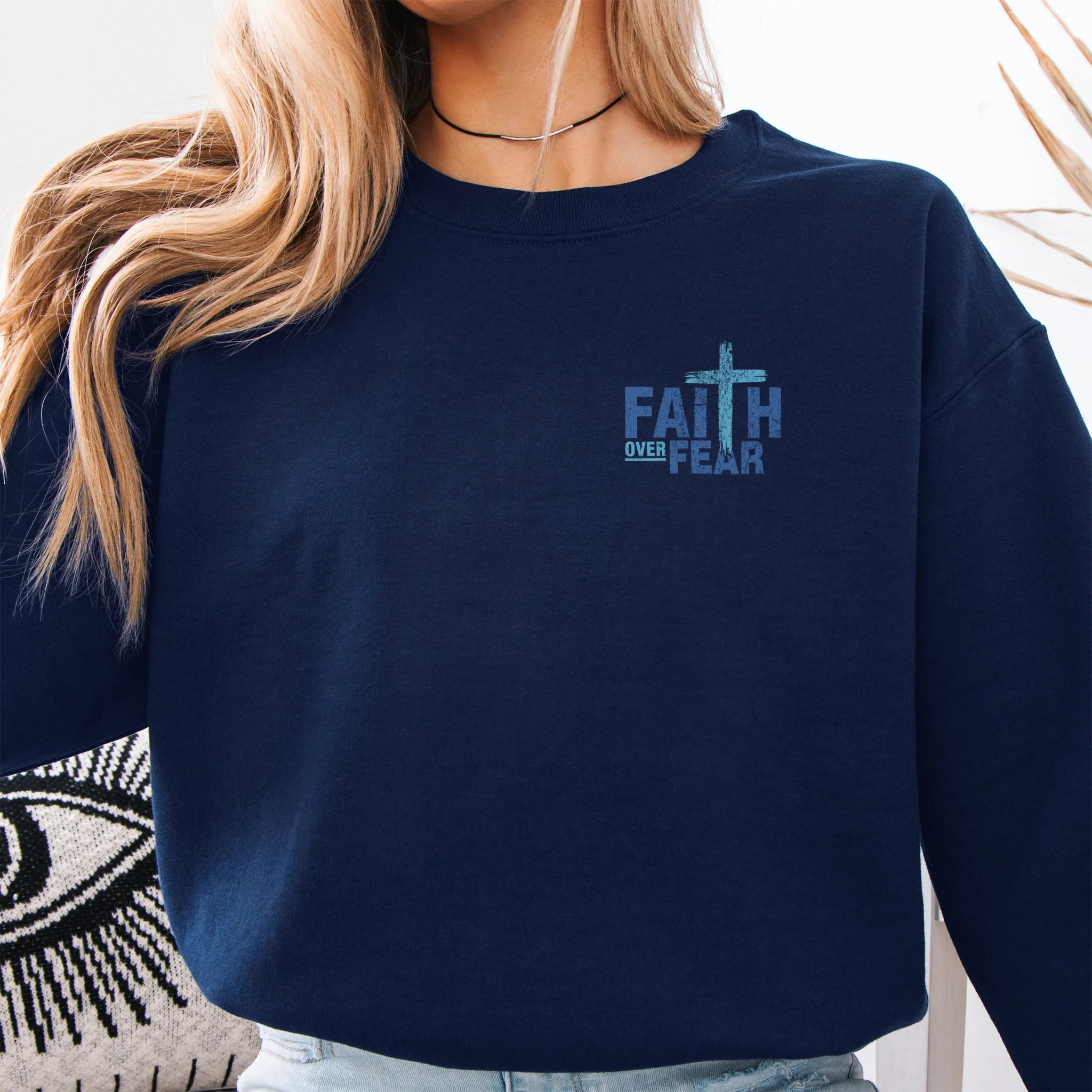 Navy Oakley June sweatshirt, left chest badge reads Faith Over Fear with small cross, relaxed modern fit, studio front view